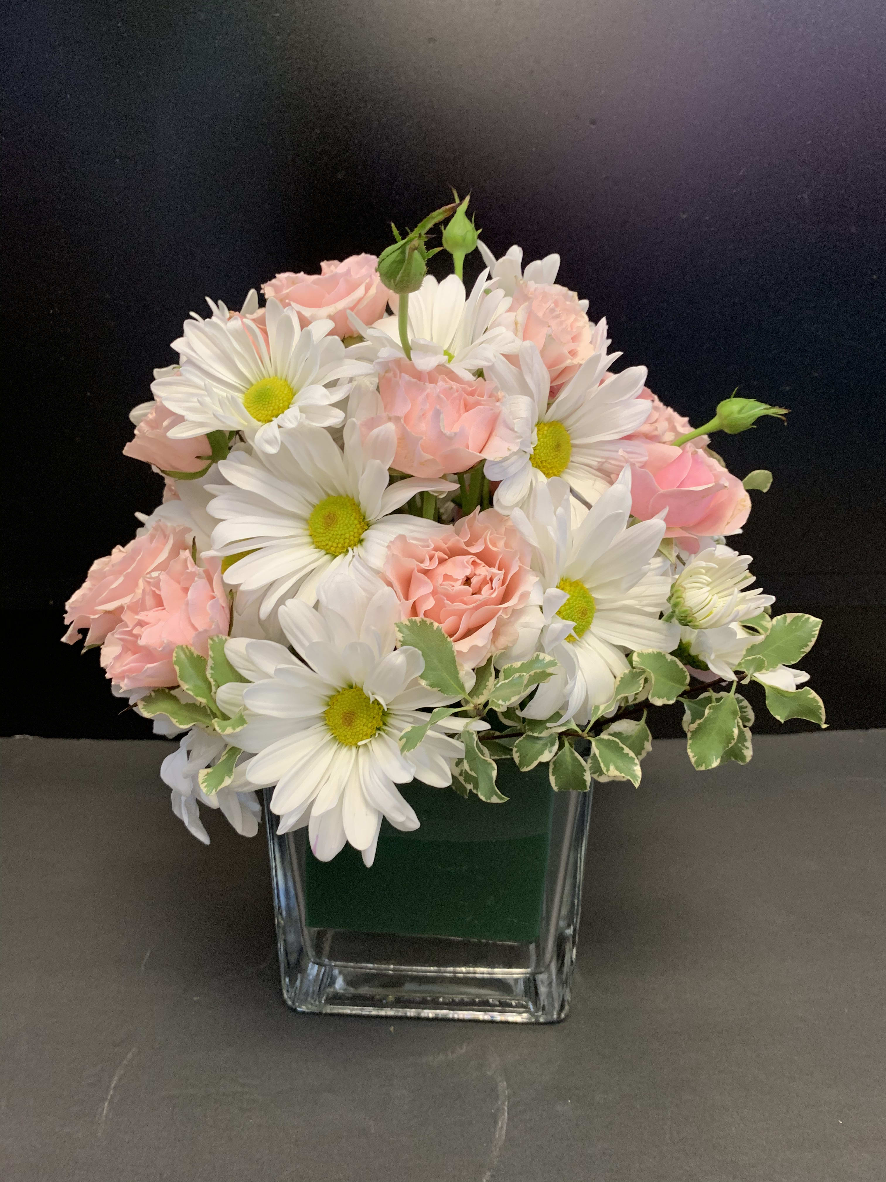 Polka Dots and Posies Polka Dots and Posies - Pop, go the flowers! This energetic pink and white bouquet pairs fresh white daisies with hot pink roses in a light pink glass cube vase. It's a fun, summery choice for your favorite girly girl!