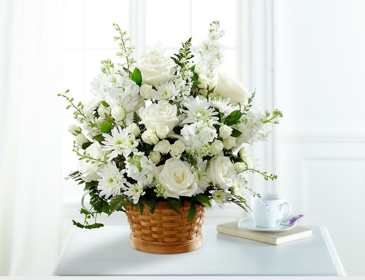 Heartfelt Condolences Arrangement Heartfelt Condolences Arrangement - Let this exquisite composition of beautiful white blossoms deliver your sympathy and comfort loved ones grieving a loss. The elegance of this arrangement and its warm, homey basket base makes it an appropriate addition to any wake, funeral or graveside service, or to send to the home of family or friends. Handcrafted by a local FTD artisan florist of individually selected white roses, stock, cushion pompons and larkspur set among complementary greens for a memorable bouquet that evokes a tranquil sense of heavenly hope. BETTER bouquet is approx. 22"H x 21"W.