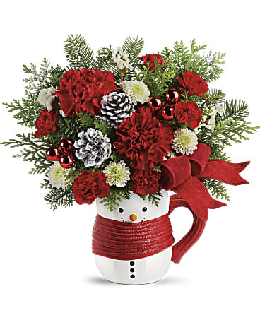 Send a HugÂ® Snowman Mug Bouquet by Teleflora - Welcome winter home with a mug of Christmas cocoa, served in this sweet ceramic snowman gift! But first, the hand-decorated design is delivered with festive holiday blooms that brighten any room. This sweet snowman bouquet features red carnations, red miniature carnations, white button spray chrysanthemums, white sinuate statice, flat cedar, and noble fir. Delivered in a Send a HugÂ® Snowman Mug.