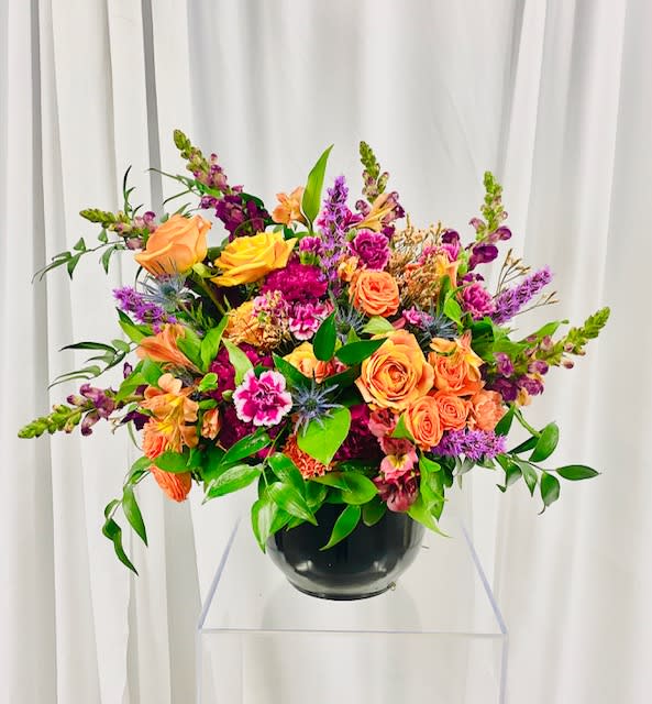 Bohemian Rhapsody - This bold design is full of color and pizazz.  It is sure to brighten your day! Flowers consist of roses, spray roses, snap dragon, carnations.  alstroemeria, greenery, and fillers.  Design to be placed in neutral colored vase.