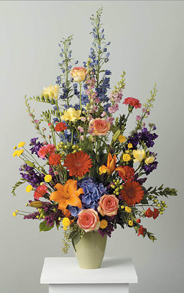 Polychromatic Stylized Vase Arrangement Polychromatic Stylized Vase Arrangement - Lilies, mini Carnations, gerber daisies, hydrangea freesia carnations, stock, heather, larkspur, hypericum, pomsps and delphinium
