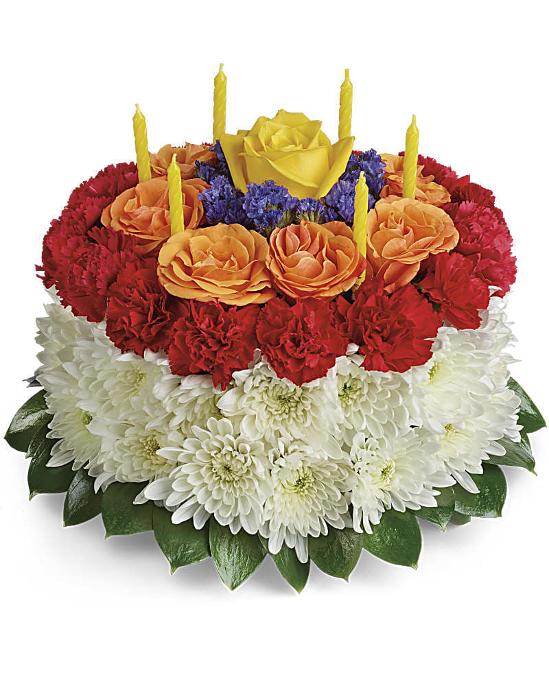 Your Wish Is Granted Birthday Cake Bouquet - A slice of birthday fun! Creative and colorful, this birthday cake bouquet of roses, carnations and mums is a fun-filled surprise on their special day. Birthday candles top it off in festive style! This cute cake arrangement is made up of yellow roses, orange spray roses, red miniature carnations, white cushion spray chrysanthemums, blue sinuata statice, and israeli ruscus. Delivered on a designer tray.