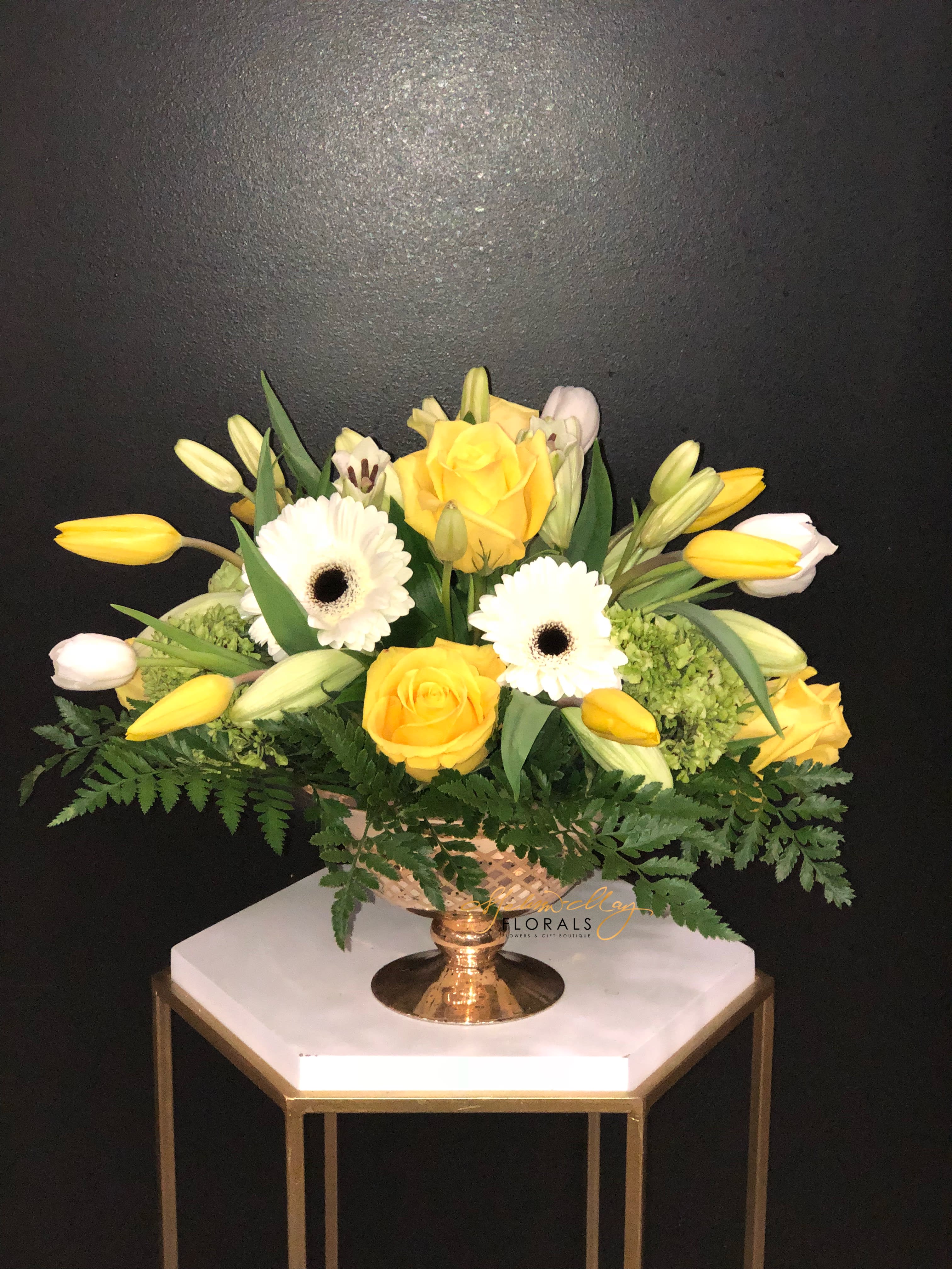 Forgiveness Garden - Rich and elegant, this all-yellow and white arrangement is a wonderful remembrance garden for your loved one. A garden that tells anyone you are forever sorry for everything. It also can tell someone that you want to forever their friend. With white gerber, yellow tulips, lush greenery and so much more. 