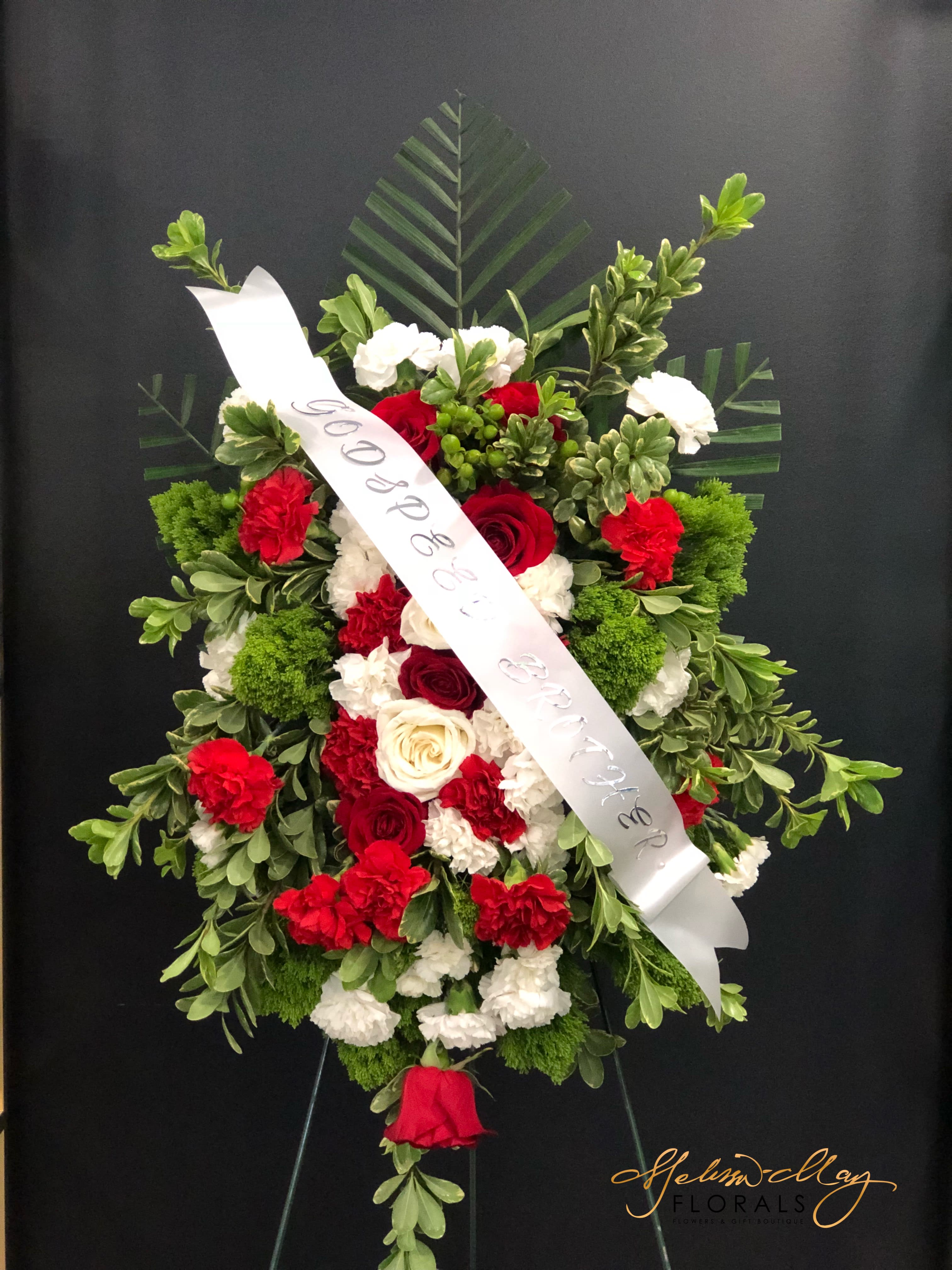 One Sided Funeral Spray - A funeral spray that is filled with red and white roses/carnations and lush greenery.  Always remember that theses flowers symbolize love and purity.  Come in and honor someone that represents nothing but love and purity. 