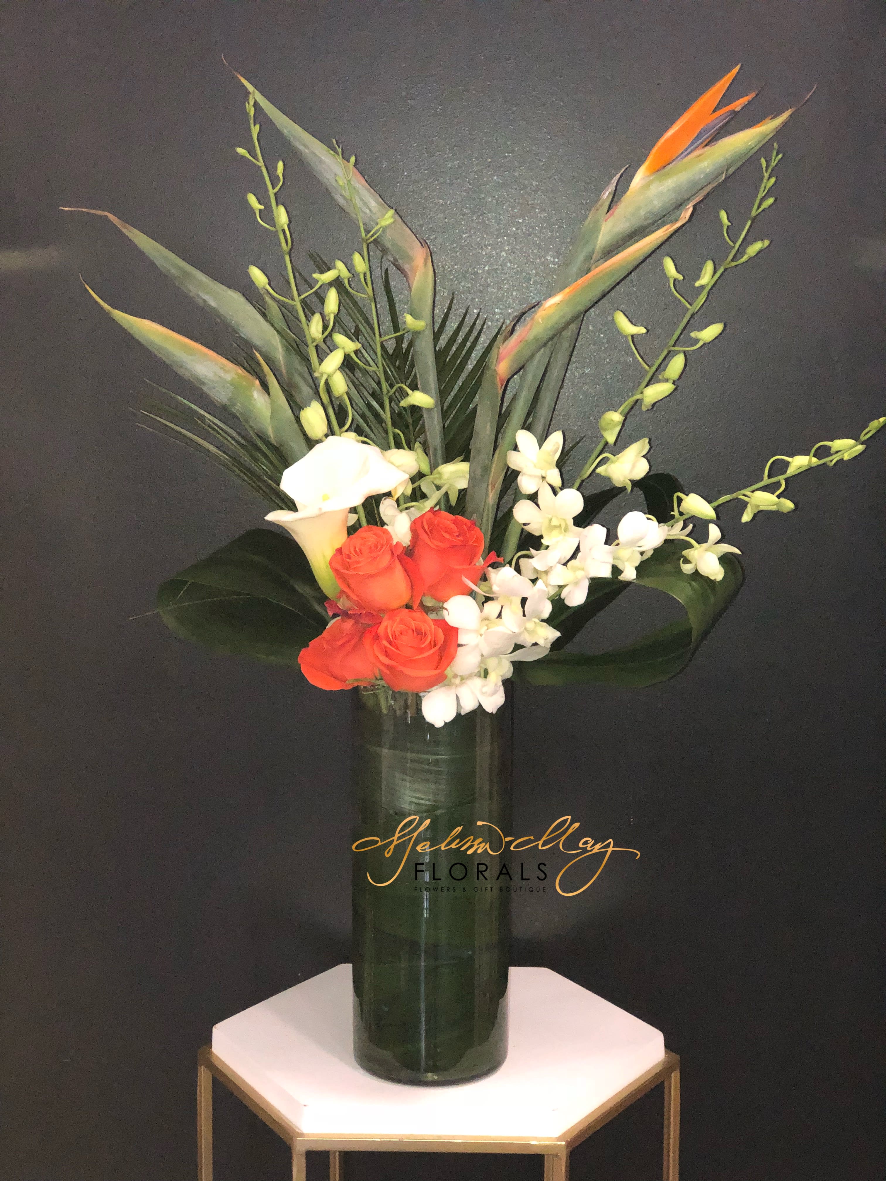 Hawaii Love - Lets bring Hawaii to your home and enjoy a one of kind piece in the privacy of your home.  An arrangement with the feel of all islands centering around you. We bring birds of paradise, orange roses, and so much more. Next day delivery is only allowed for this order.