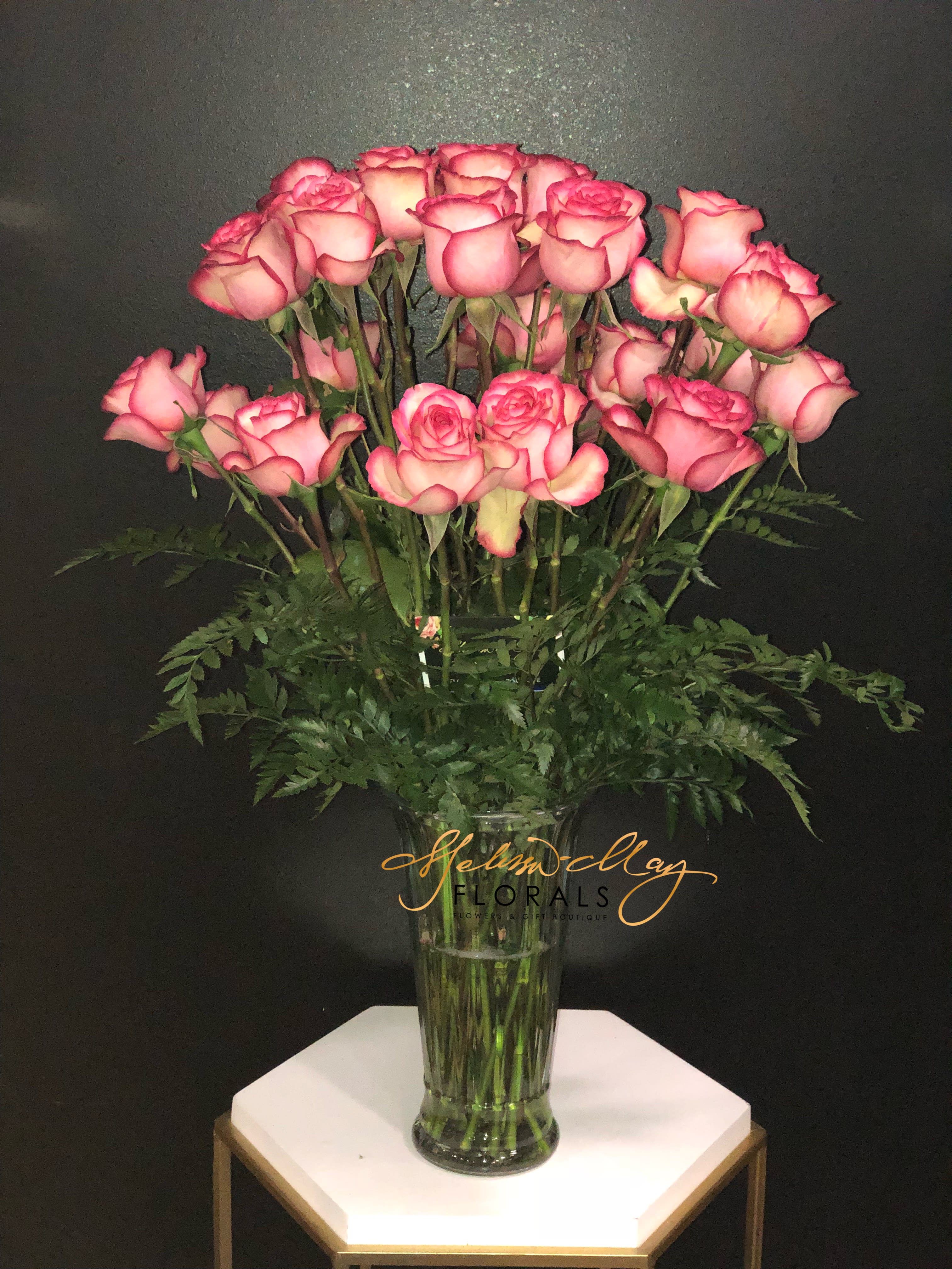 Passion of Love (Picture shown is a Deluxe) - Picked fresh from the Passion™ Growers Farm to bring a flair of color &amp; light straight to their door, the Passion of Love Rose Bouquet is a bouquet they won't forget!. This fresh bouquet of Dynamite variety roses, known for its bicolored white petals with red tips, is accented with a variety of lush greens to shower your recipient with merry wishes &amp; joy.  BETTER bouquet includes 18 stems with vase. Approximately 24-inches in height. Your purchase includes a complimentary personalized gift message.