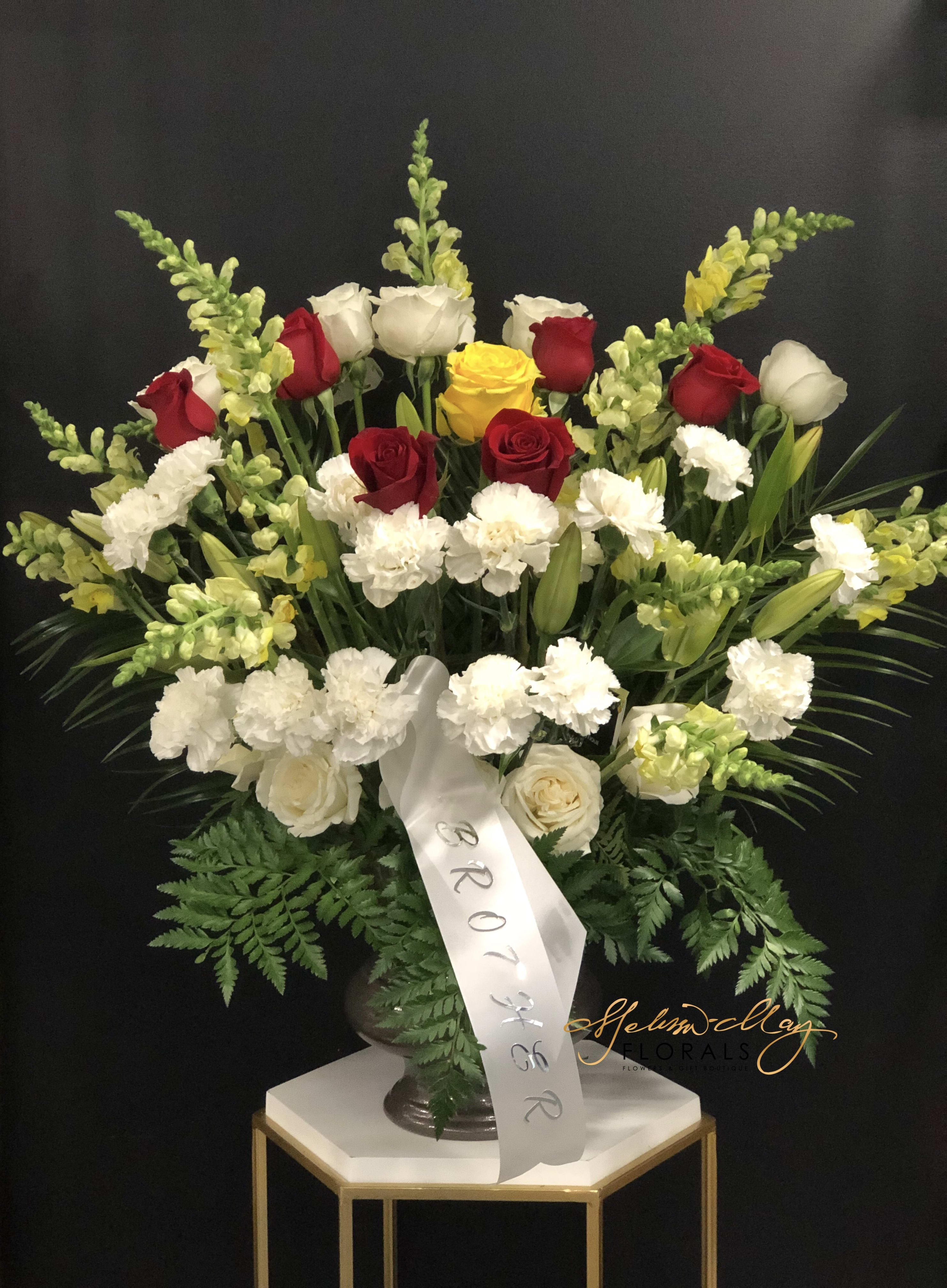 Free Your Heart - When your heart is broken it may not be the easiest to repair it. A funeral spray of this statue will help you recover your heart. This arrangement comes with green snapdragons, white carnations, and red roses. 