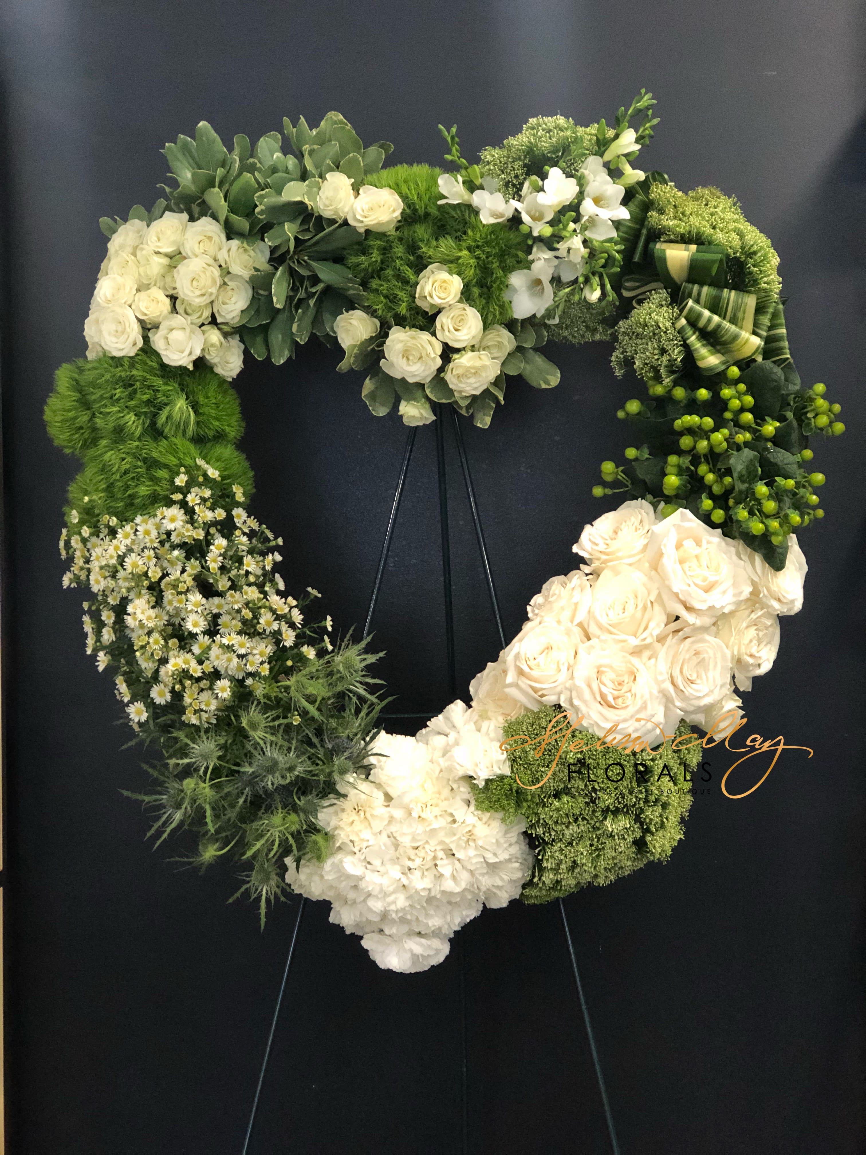 Green Love - A blend of green and white gives you memories of being on the golf course or out with nature. Either way you can not go wrong with this master piece. This piece surely showcases your love for everything green. An arrangement in the shape of your heart big and beautiful. With roses, carnations, and so much more. 