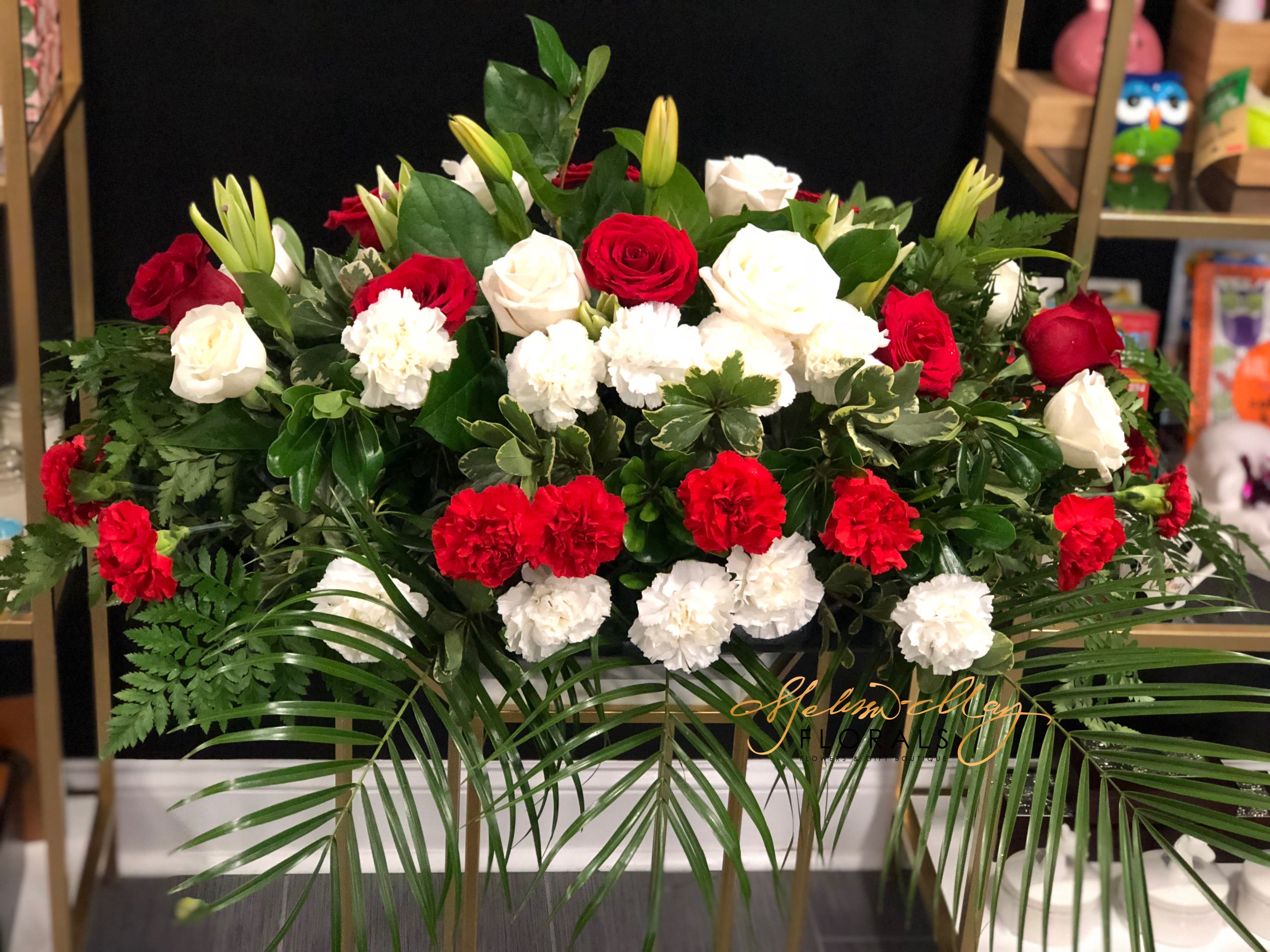 Garden of Home - The garden of where home is and you never want to go anywhere else. You will not be disappointed with this to celebrate someone home going. A spray filled with red and white roses/ carnations as well as lilies on top. 