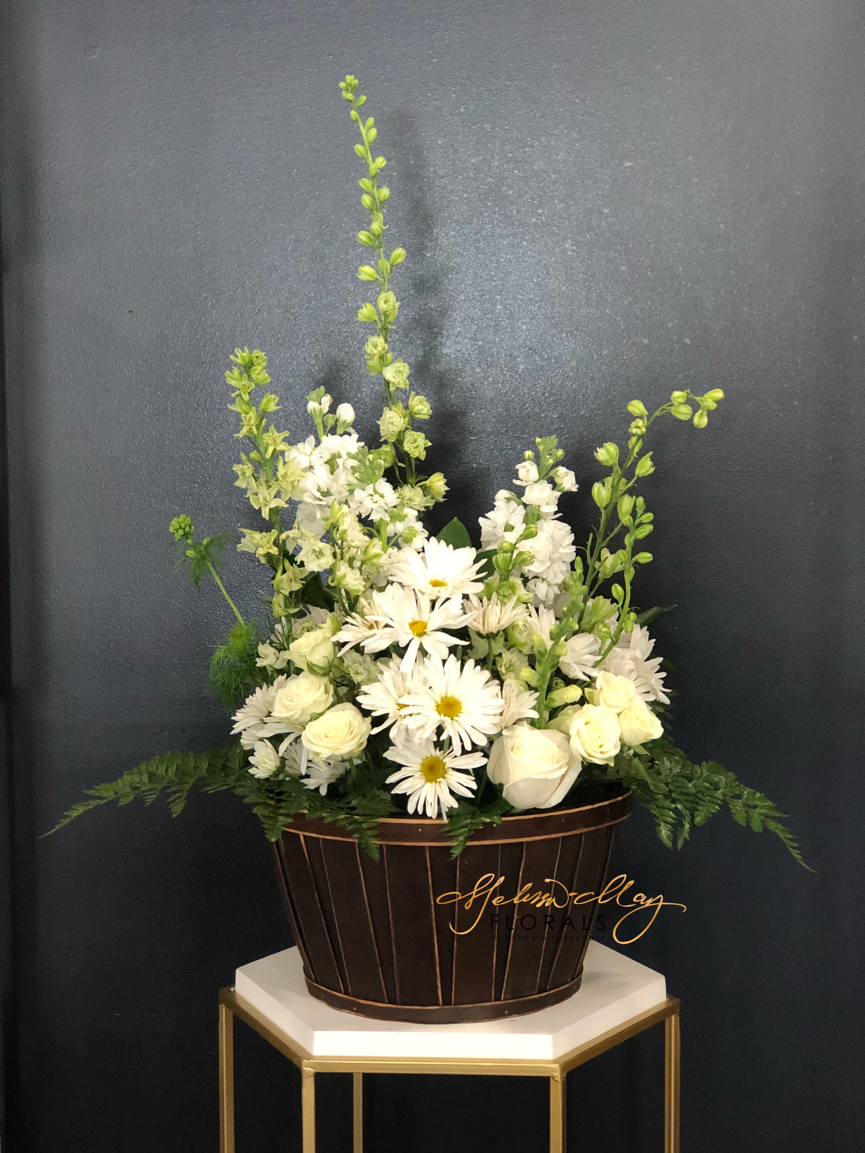Basket of Love - A basket filled with all your favorite white flowers. You will fall in love not only with how the flowers were placed together to make this arrangement like no other but with all the basket itself. It has spray roses, daisies, stock, and more.  (Vase in image is no longer available. A substitute will be used.)