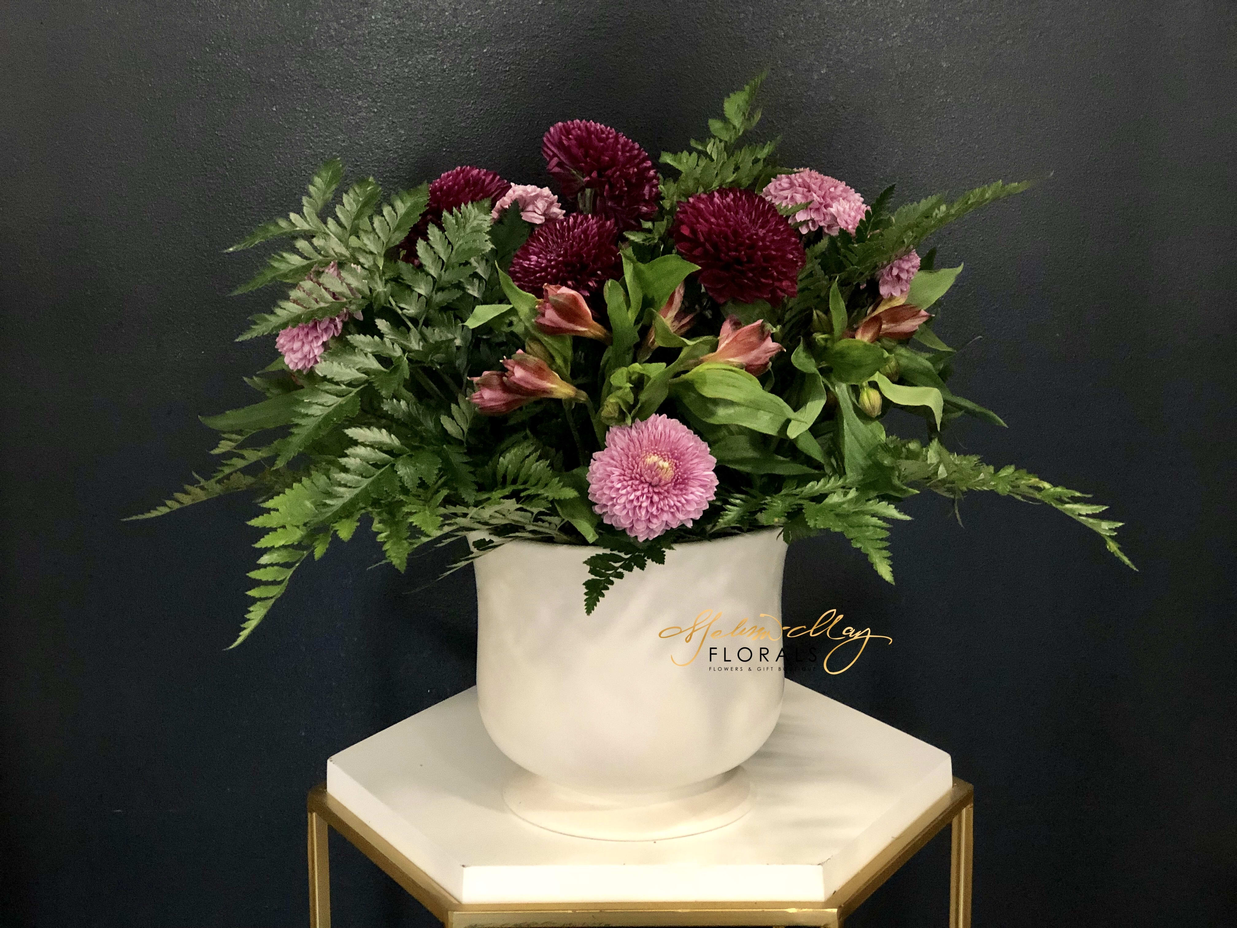 Peaceful Purple - Purple represents peace, creativity, and extravagance. A subtle but organic piece that brings nothing but peace in a room. With purple cushion mums and alstroemerias all the way around. (Vase in image is no longer available. A substitute will be used.)