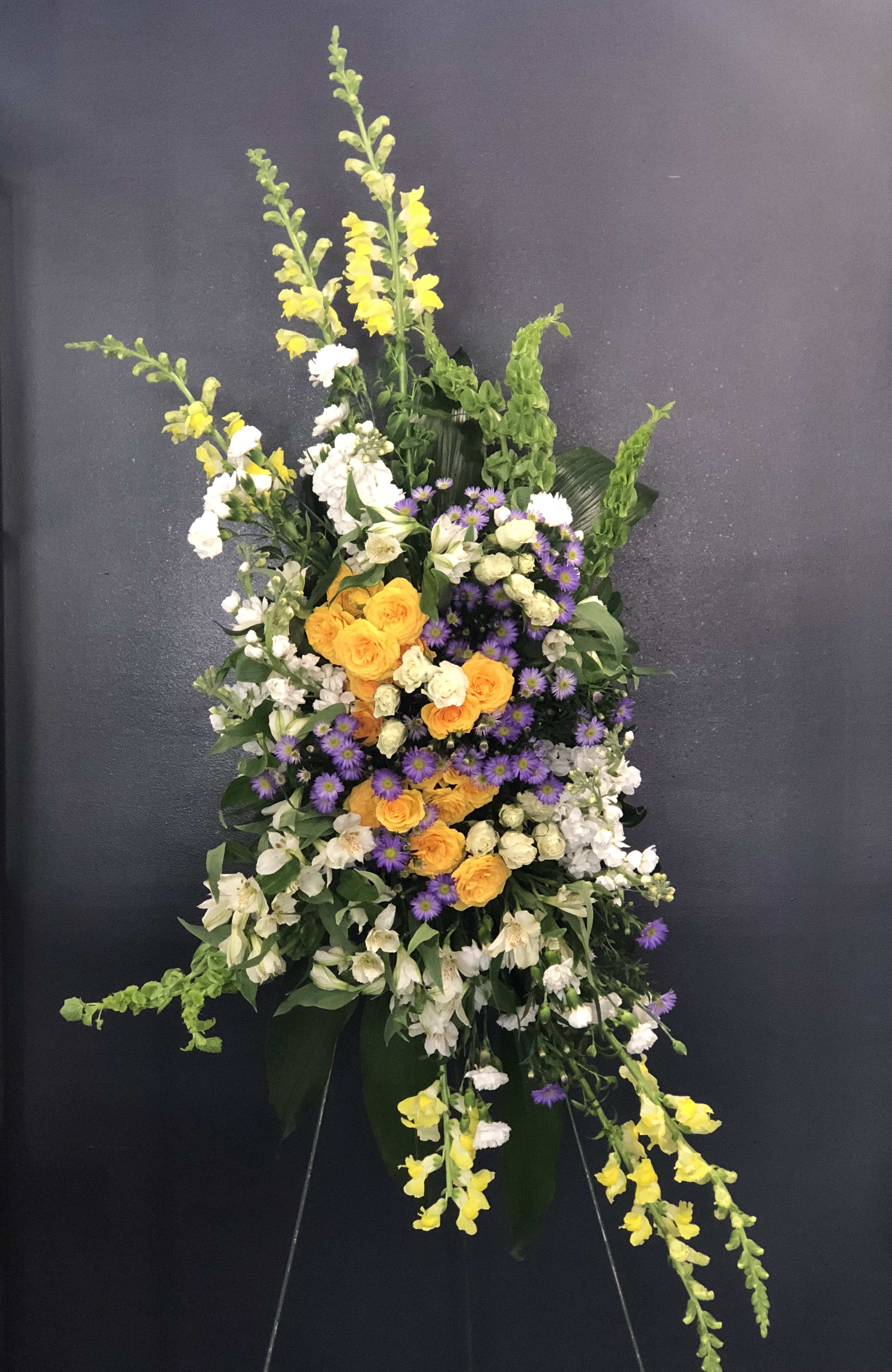 Wild Garden - Its a garden of flowers that you will never imagine that you would loved together. It is no secret we take pride in making our arrangement the talk in the town. Its filled with yellow spray roses, snapdragons, bells of Ireland, and so much more. 