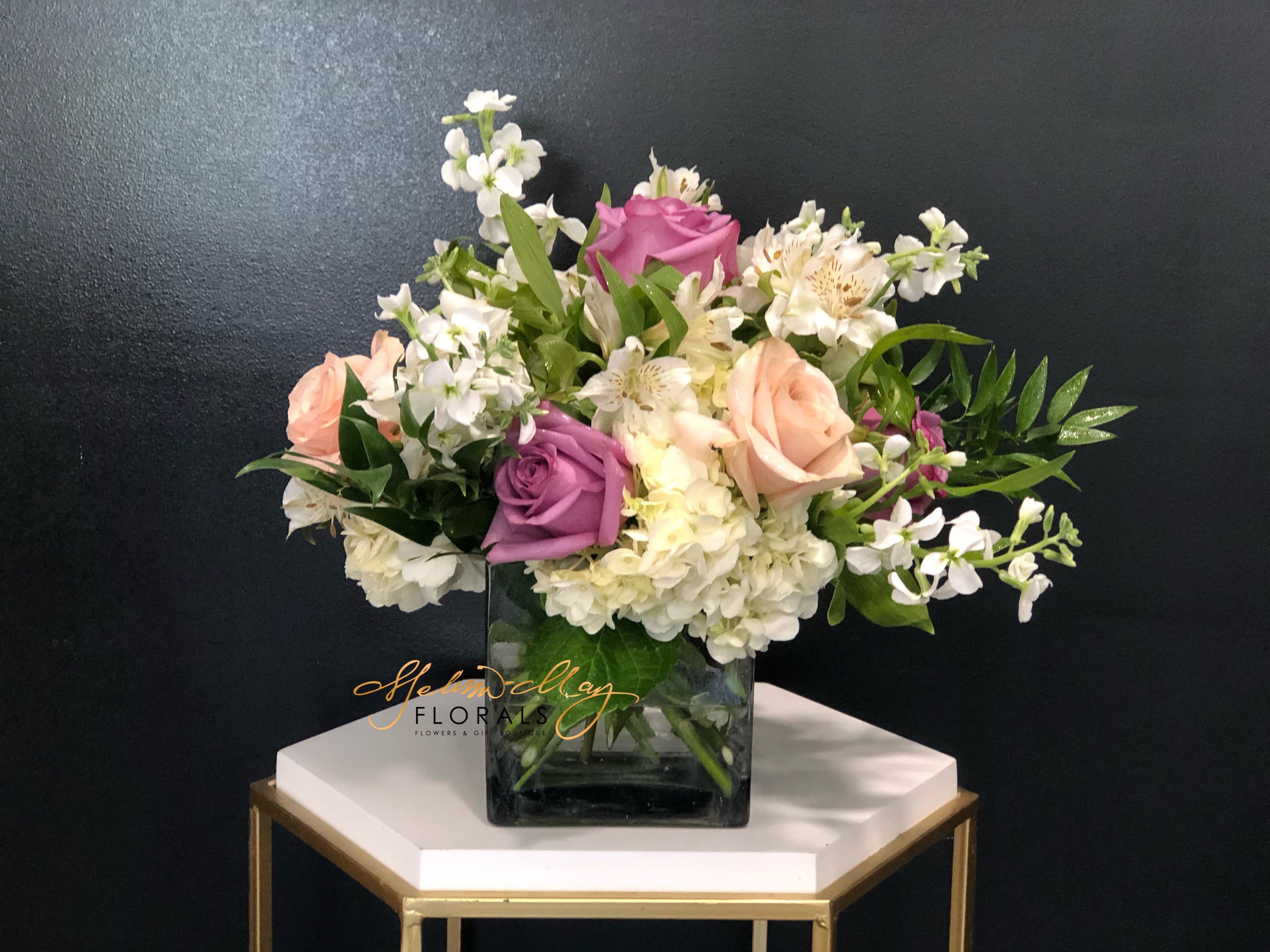 Forever Elegance - A gorgeous and chic flower arrangement for the person in your life who loves things that dazzle and blow them away. A captivating color combination that begs for your attention; White Hydrangeas, Purple and Blush Roses, White Stock and White Alstroemeria. How luxurious! Show them how much you admire them by sending this totally stunning floral arrangement.  