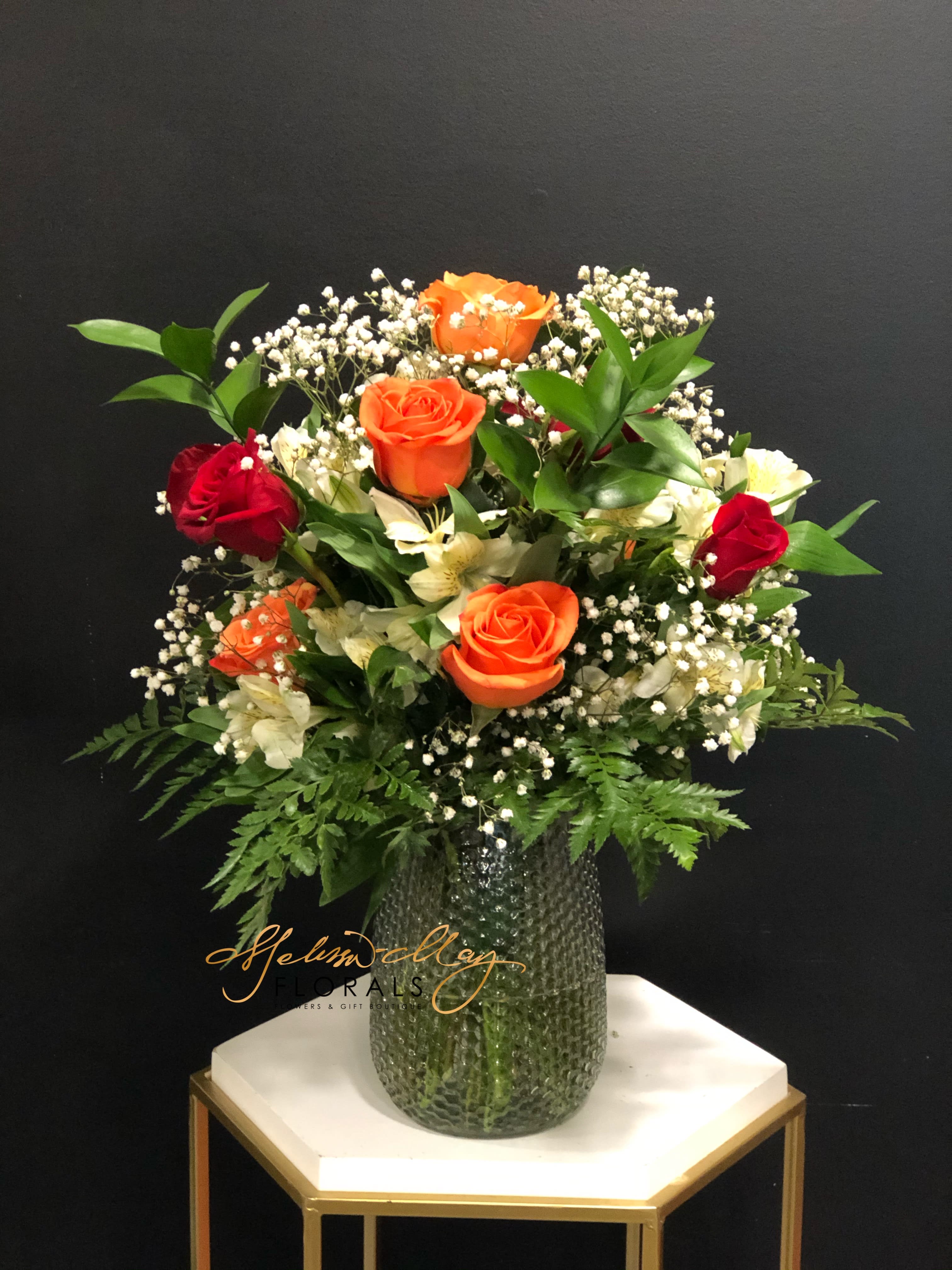Sweet Autumn Burst - This is for the Bright and cheerful lady or gentleman in your life. This arrangement has a mixture bright colored roses, alstroemeria and lush greenery. 