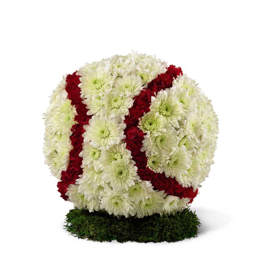 All-American Tribute Baseball - The All-American Tribute Baseball is a lovely way to commemorate the life of your loved one. White chrysanthemums and red mini carnations form the shape and likeness of a baseball standing on piece of lush green moss, to create a wonderful way to remember the deceased and their favorite pastime at their memorial service.