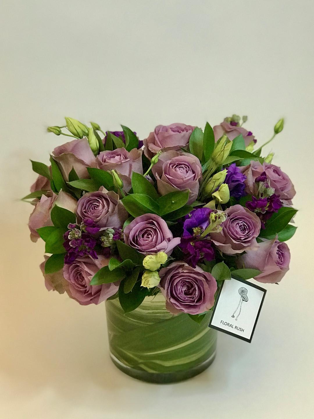 Purple Crisp - For the person that loves purple:  purple roses, purple lisianthus, stock in leaf wrapped cylinder