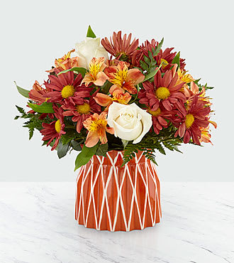 Shades of Autumn Bouquet - Our handcrafted Shades of Autumn Bouquet is designed to bring the comfort and warmth of the harvest season indoors. A collection of vendela roses, orange spray roses, bronze daisy pompons and more are set in a seasonal orange and white decorative vase to make any home feel bright. Perfect for coming together this season and giving thanks, this arrangement is sure to add beauty to any Autumn occasion! 