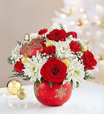 Shimmering Star Ornament - EXCLUSIVE Our floral designers have handcrafted an arrangement of roses, poms, carnations and more inside our new, elegant ceramic ornament container featuring a ruby satin finish accented by a delicate pattern of glittering gold stars. A substantial keepsake that will have a place on the mantel year after year, it has a removable lid... so when the flowers expire, the food-safe décor piece can be used to hold candies or other treats. Whoever is lucky enough to receive this gift will treasure it for years to come.
