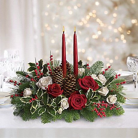 Christmas Wishes Centerpiece -  Your wishes for a classic Christmas centerpiece have come true! This elegant arrangement features two glowing red taper candles atop a bed of noble fir, white pine and luxurious roses.      Red and white roses are mixed with festive noble fir, white pine and variegated holly beneath two red taper candles.     Red berries and pinecones add to the Christmas fun.     Orientation: All-Around  