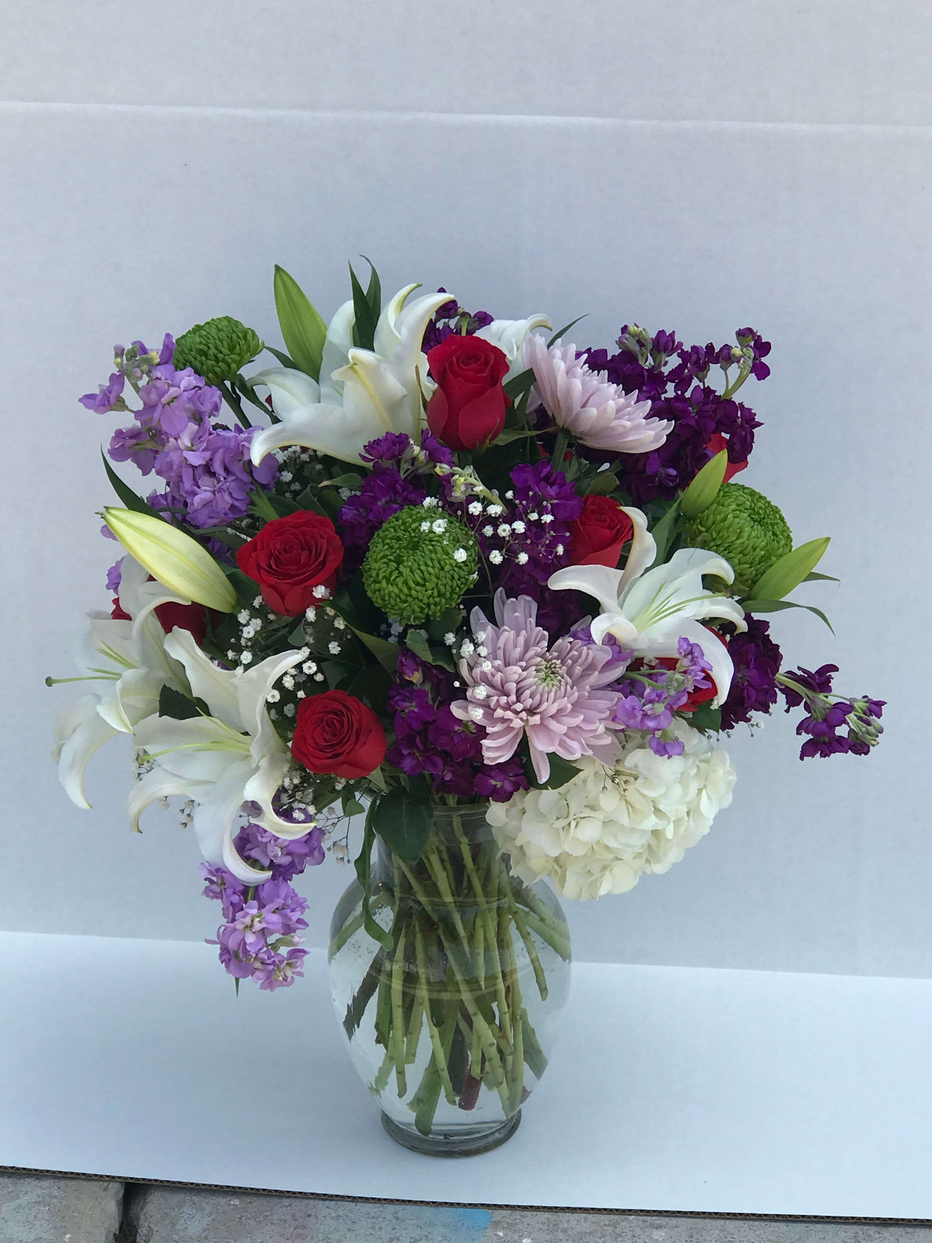 lavender thoughts - Fresh  floral arrangement with white lilies, lavender and purple stock, green spider flower, got pink roses, lavender mums about 17 to 20 steams in a 12&quot; ginger vase 