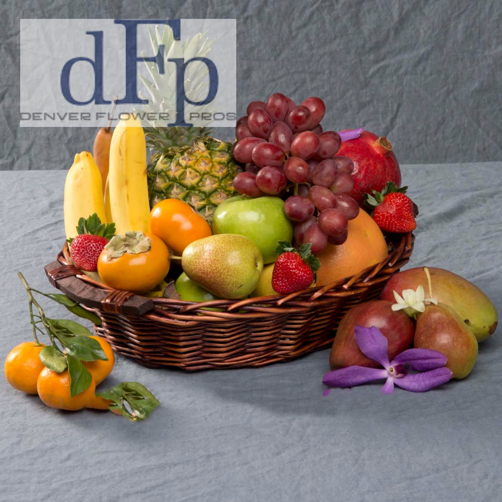 Fresh Fruit Basket Fresh Fruit Basket - Premium Fresh Fruit in a wicker basket. This large basket contains seasonal premium fruits. Decorated with greens and fresh flowers