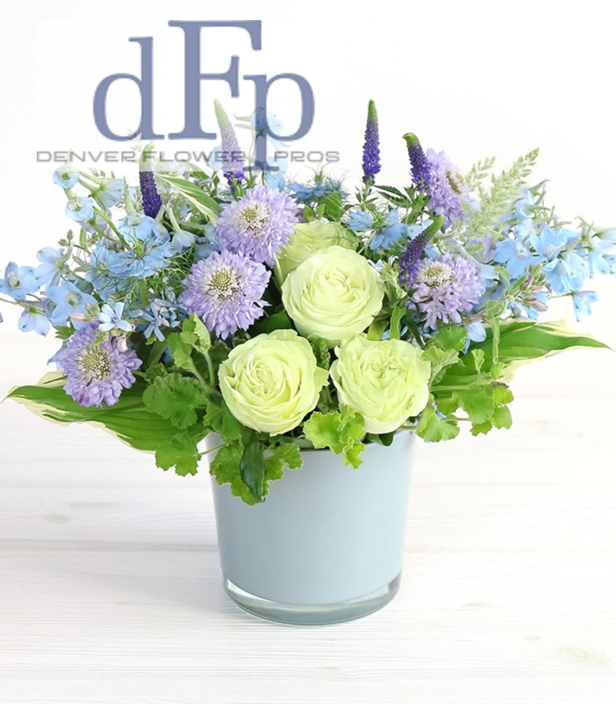 Winter Blue Arrangement Winter Blue Arrangement - A wonderful winter blue flower arrangement . Cool blues with white and greens . Arrangement can contain . Hydrangea, Delphinium, garden or premium roses , Whintery greenery like olive and laurel