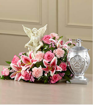 The FTD® Divinity™ Arrangement The FTD® Divinity™ Arrangement - This extraordinary mixed flower bouquet delivers your sympathy with a beauty and faith that reflects the love and loss you feel. The asymmetrical bouquet is hand-arranged by a local FTD artisan florist to make a reverent and respectful setting for an urn of the deceased's cremated remains. Around an angel sculpted of artist's resin are pink roses, carnations, Stargazer lilies, statice and lush greens in a tabletop container that's not visible when set on a flat surface. It makes a fitting focal point for a wake or funeral service. Your purchase includes a complimentary personalized gift message.