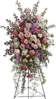 Our Thoughts Our Thoughts - Warm tones of flowers arranged in a standing easel spray.