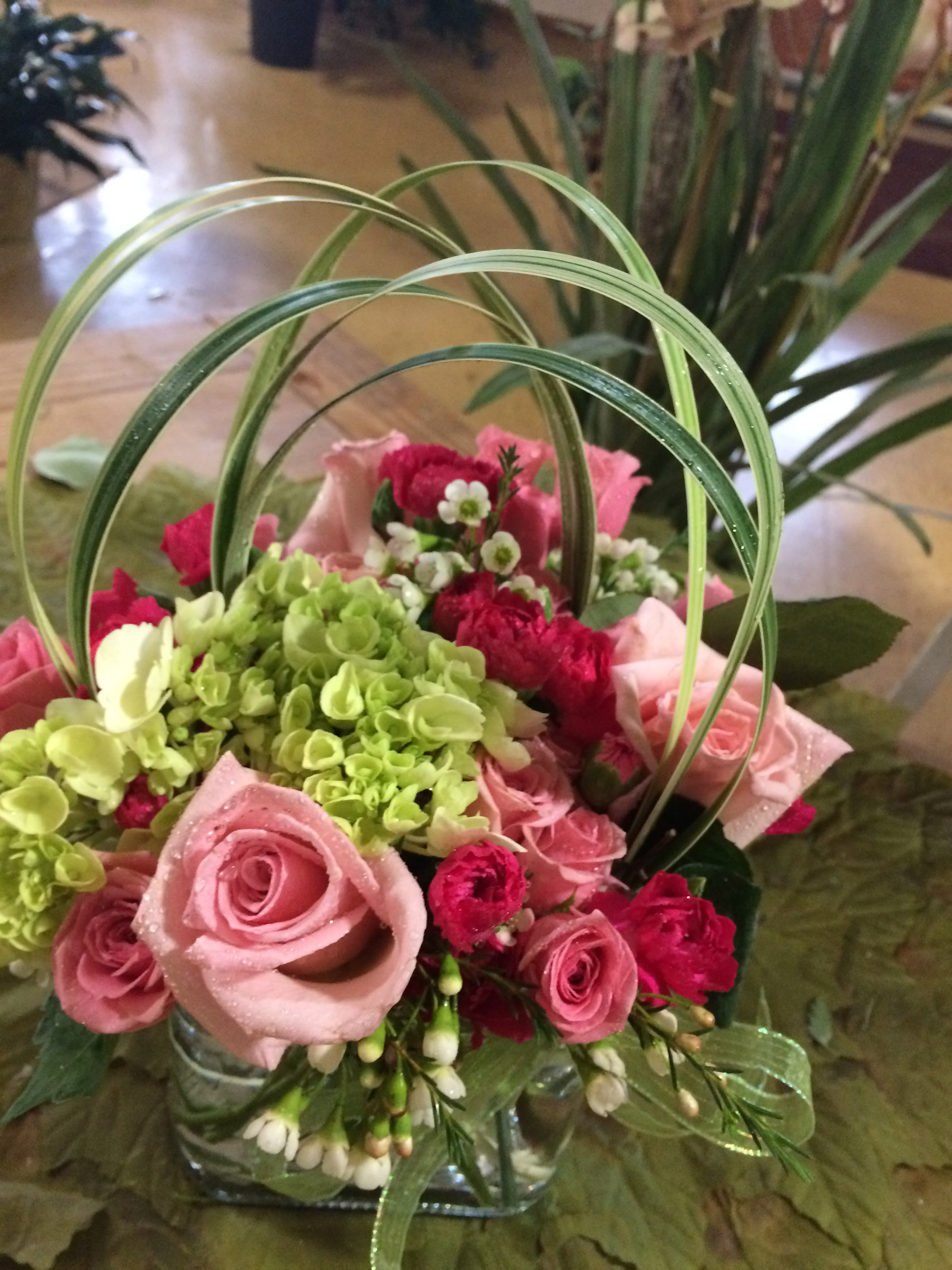 Cotton Candy - Green hydrangea, with pink roses and pink spray roses, with lily grass crossing the top. 