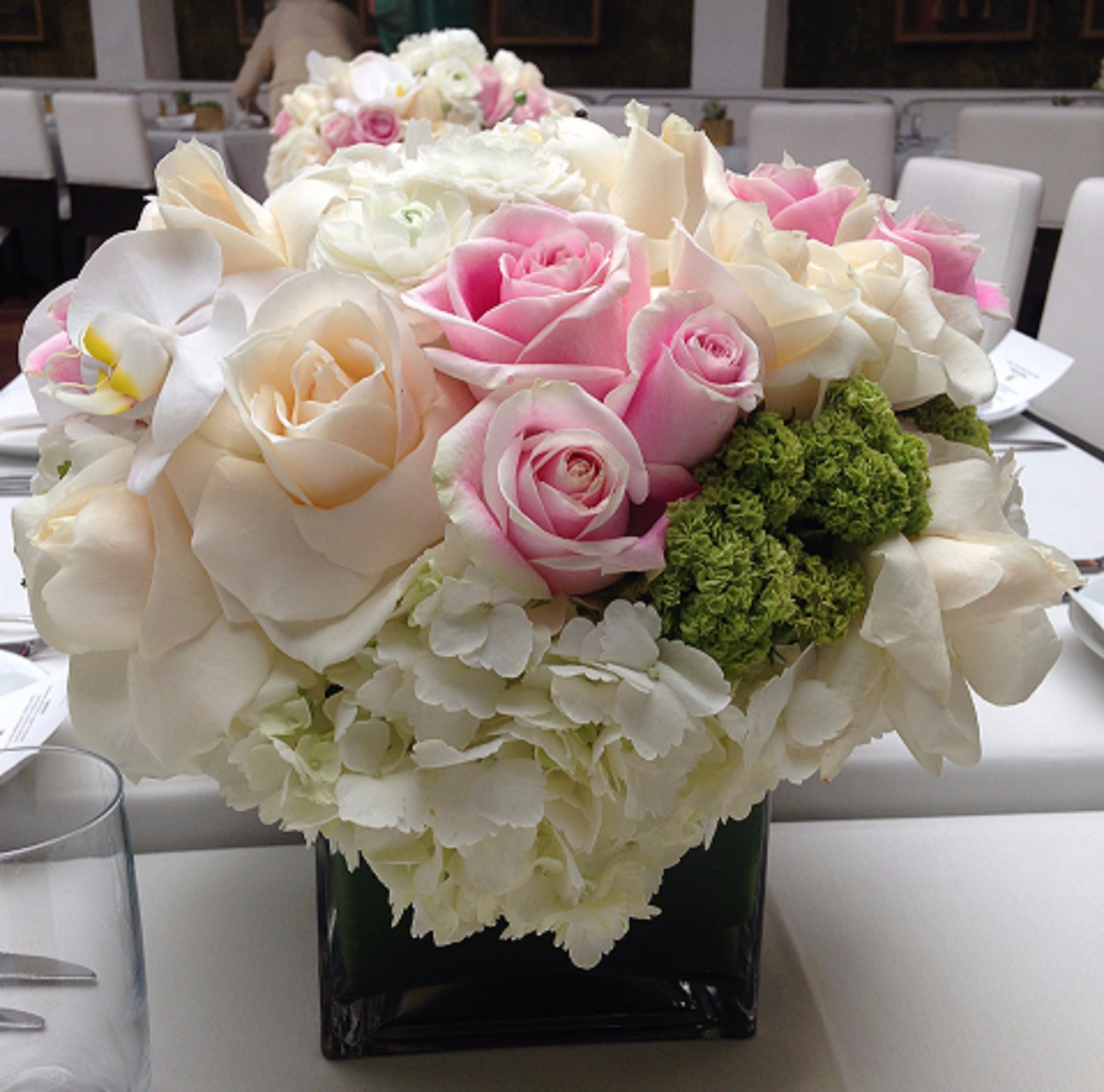 Elegant Combination Elegant Combination - Burst of white Hydrangeas, green Vibenum and a mixture of Roses with Phalaenopsis Orchids in a square clear glass. Comparable substitutes will be used for seasonal flowers.