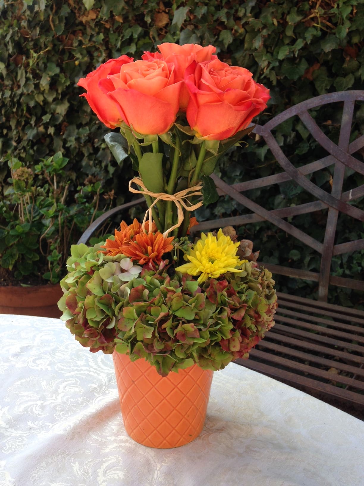 Fall Topiary - This is a festive fall topiary with bright orang roses designed with Hydrangeas and mums in beautiful bright orange ceramic container.