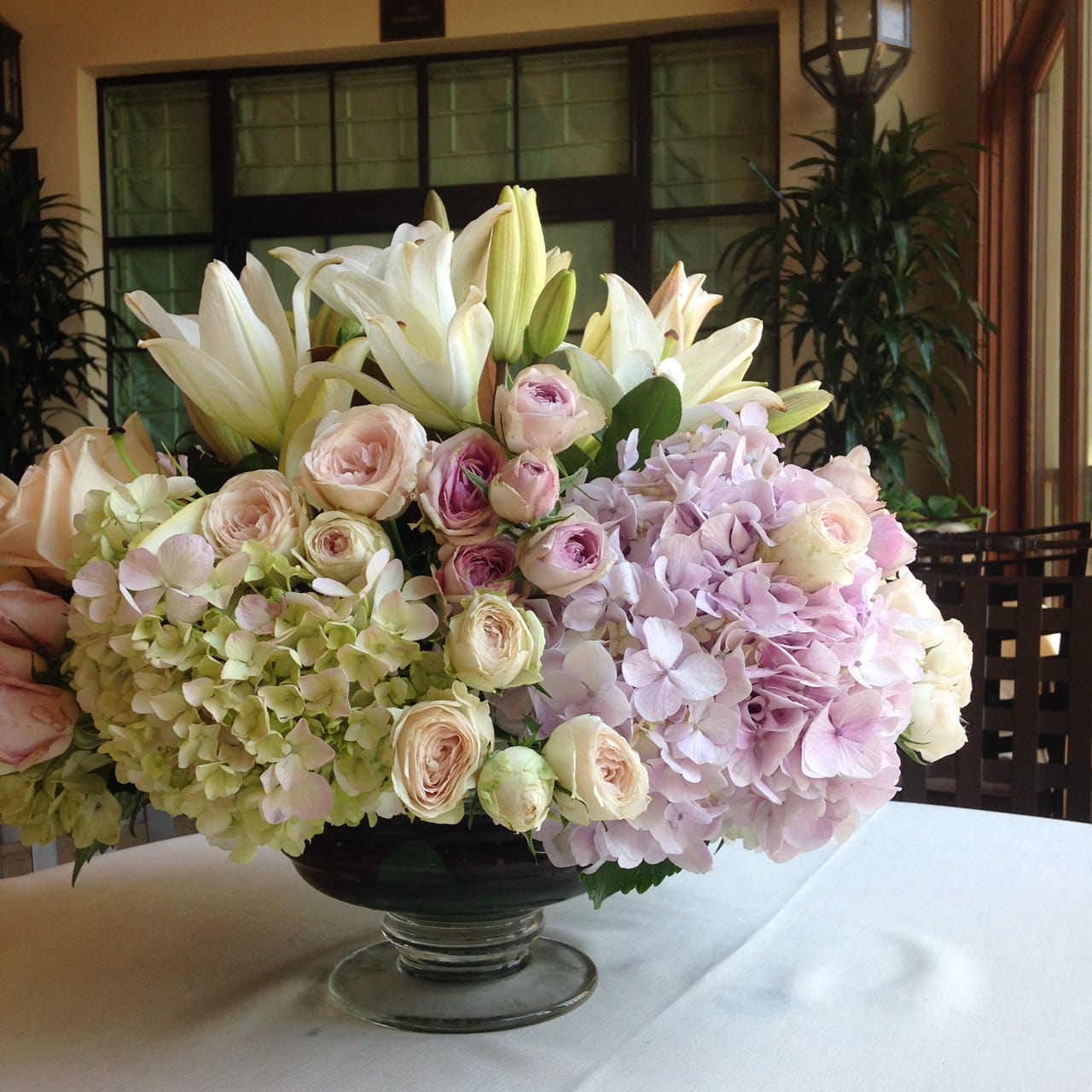 Celebration with rainbow - Combination of fluffy soft color Hydrangeas and garden roses with passion flowers and white lilies design in an elegant container