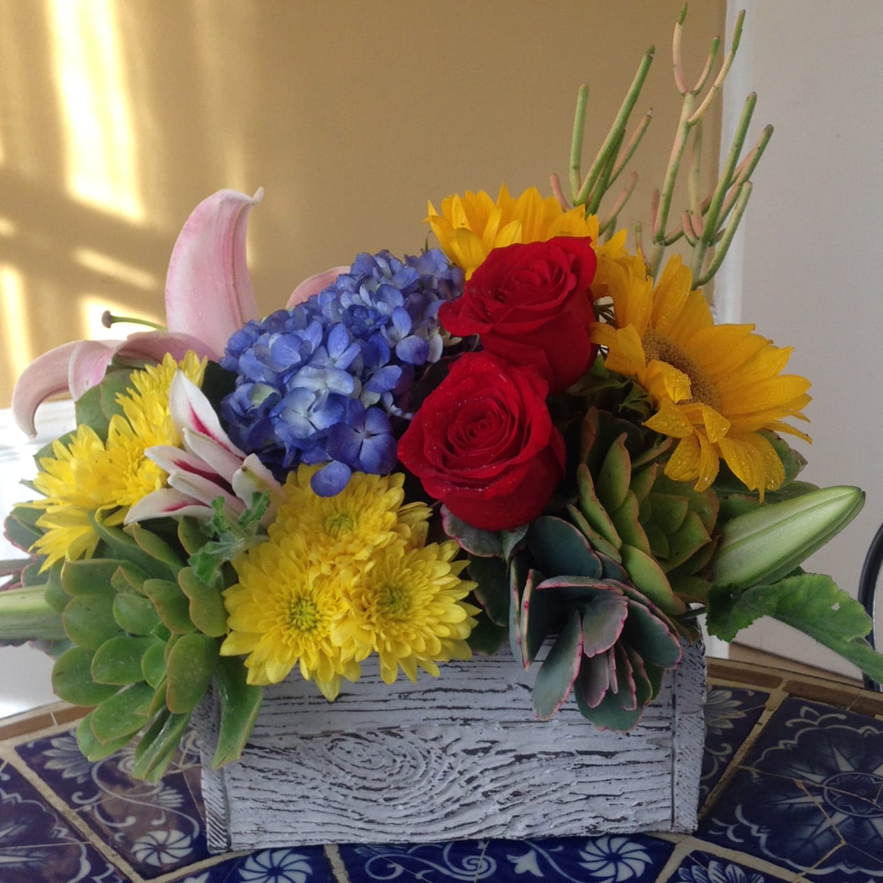 Sunflowers with succulents - Bright sunflowers with variety of reusable succulents combined with red roses and red lilies in a sweet box. The succulents can be planted in the pot or garden after you enjoyed the arrangement.  