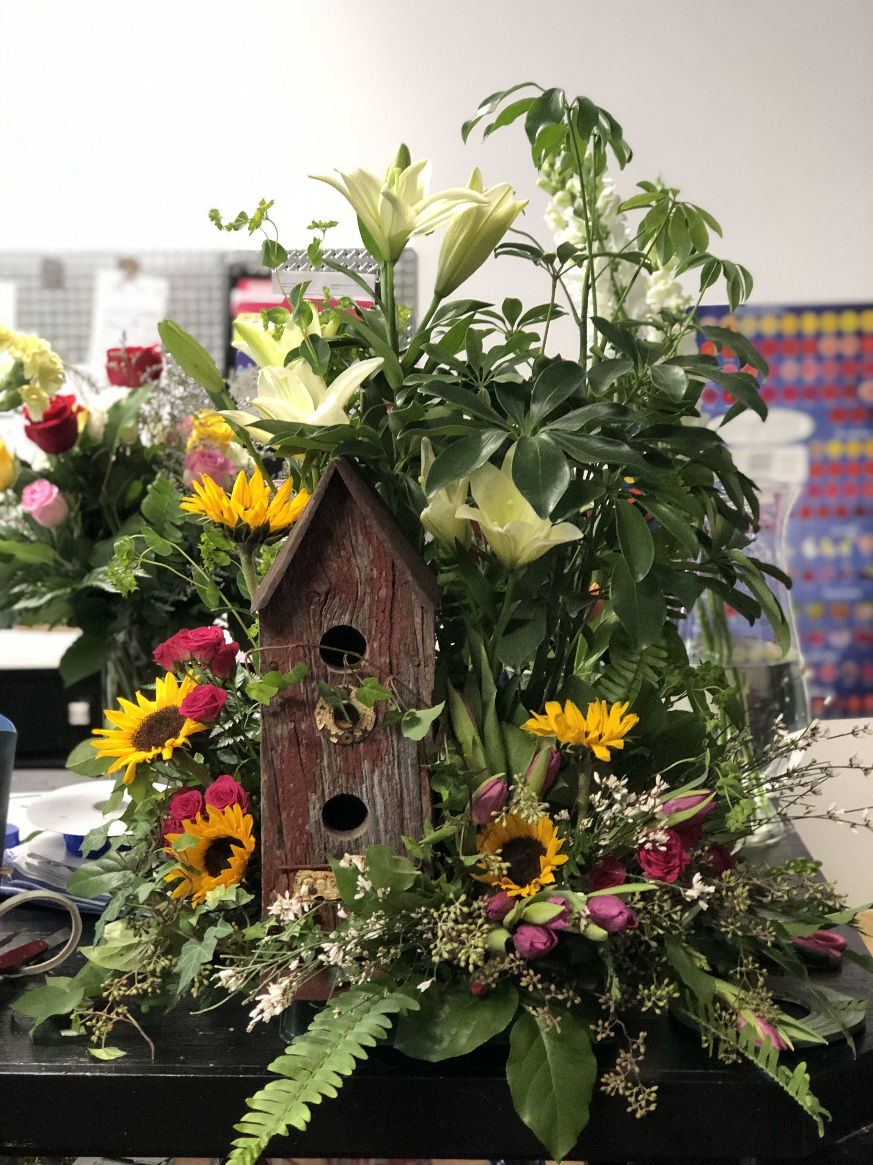 Bird house planter Bird house planter - If you are wanting a keepsake, this is your go to arrangement. It contains a bird house, mixed plants, and some fresh cut flowers. There's a little bit of everything, but once the flowers are done, the recipient still has a beautiful bird house and plant as a memory of the occasion.