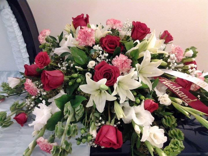 Red, white, pink &amp; green Casket Spray - This loving memorial piece has roses, lilies, bells of Ireland, baby's breath, lilies, carnations, glads &amp; mixed greens.