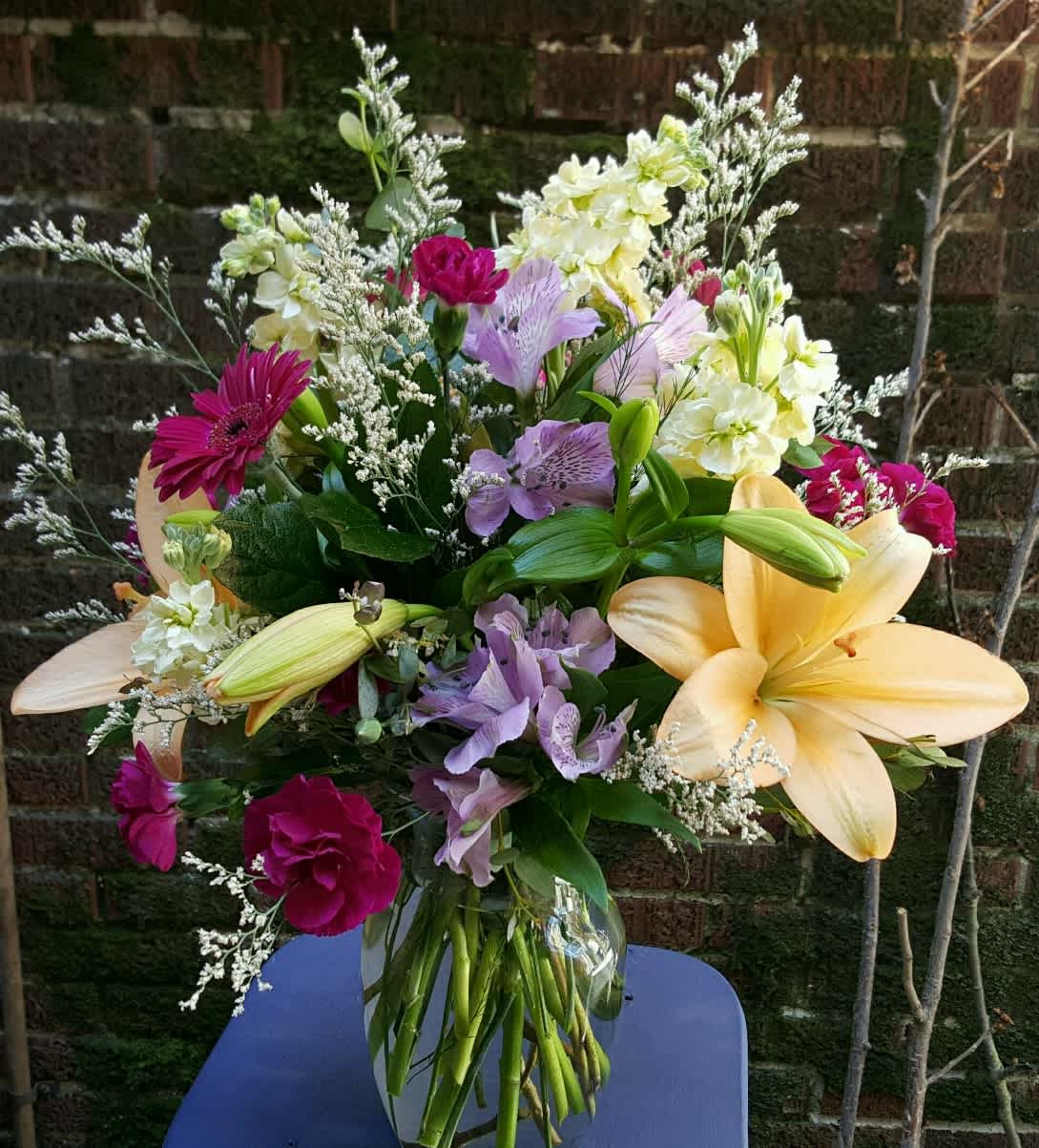 A spring colored mixture of flowers - A mixture of lilies, mini carnations, mini gerbera, stock, alstroemeria and other flowers &amp; greens.