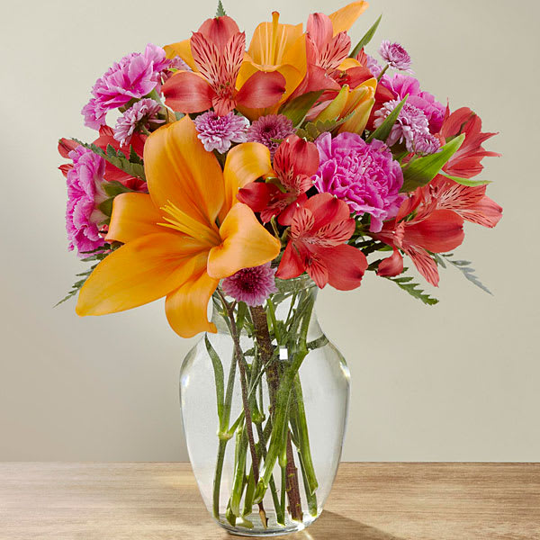 The Light of My Life Bouquet The Light of My Life Bouquet - The Light of My Life™ Bouquet blossoms with brilliant color and a sweet sophistication to create the perfect impression! Orange Asiatic Lilies make the eyes dance across the unique design of this flower bouquet surrounded by the blushing colors of red alstroemeria lavender button poms fuchsia carnations and lush greens. Presented in a clear glass vase this fresh flower arrangement has been created just for you to help you send your sweetest thank you happy anniversary or thinking of you wishes. GOOD bouquet is approx. 16"H x 13"W. BETTER Bouquet is approx. 17"H x 14"W. BEST bouquet is approx. 18"H x 15"W.