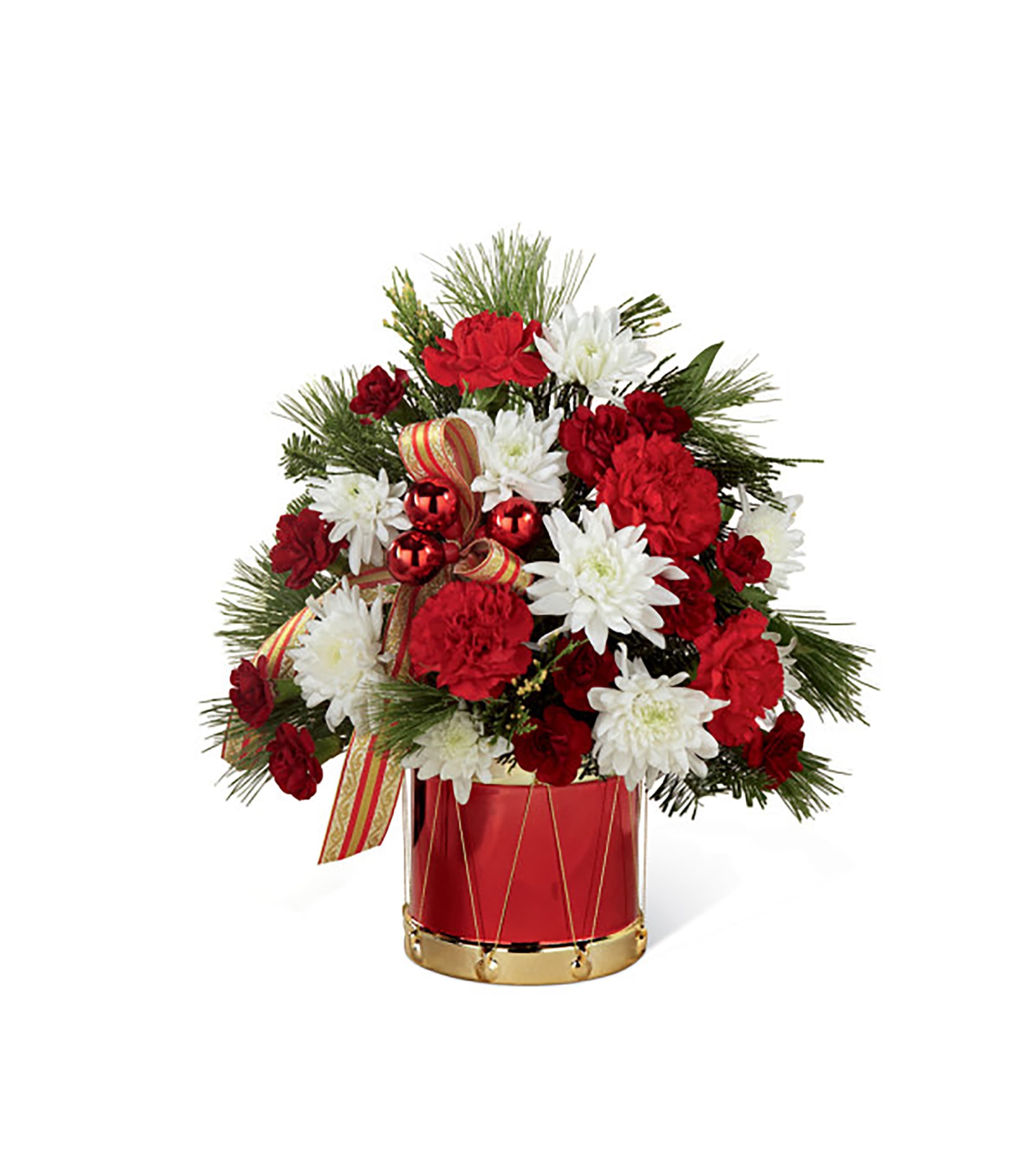 Happiest Holiday Bouquet Happiest Holiday Bouquet - Drum up plenty of holiday cheer with this joyful floral display that never misses a beat when it comes to spreading Christmas cheer. Red roses and white Asiatic lilies (in Deluxe, Premium, and Exquisite versions only) and white cushion pompons make a snowy counterpoint to the rich burgundy carnations, glistening glass balls and fancy striped ribbon bows. It's all beautifully hand-arranged in a delightful toy drum-inspired vase. Whether you're looking to strike a charming "Little Drummer Boy" note or celebrate with a "toyland" parade, this bouquet delivers the perfect accompaniment to your holidays.