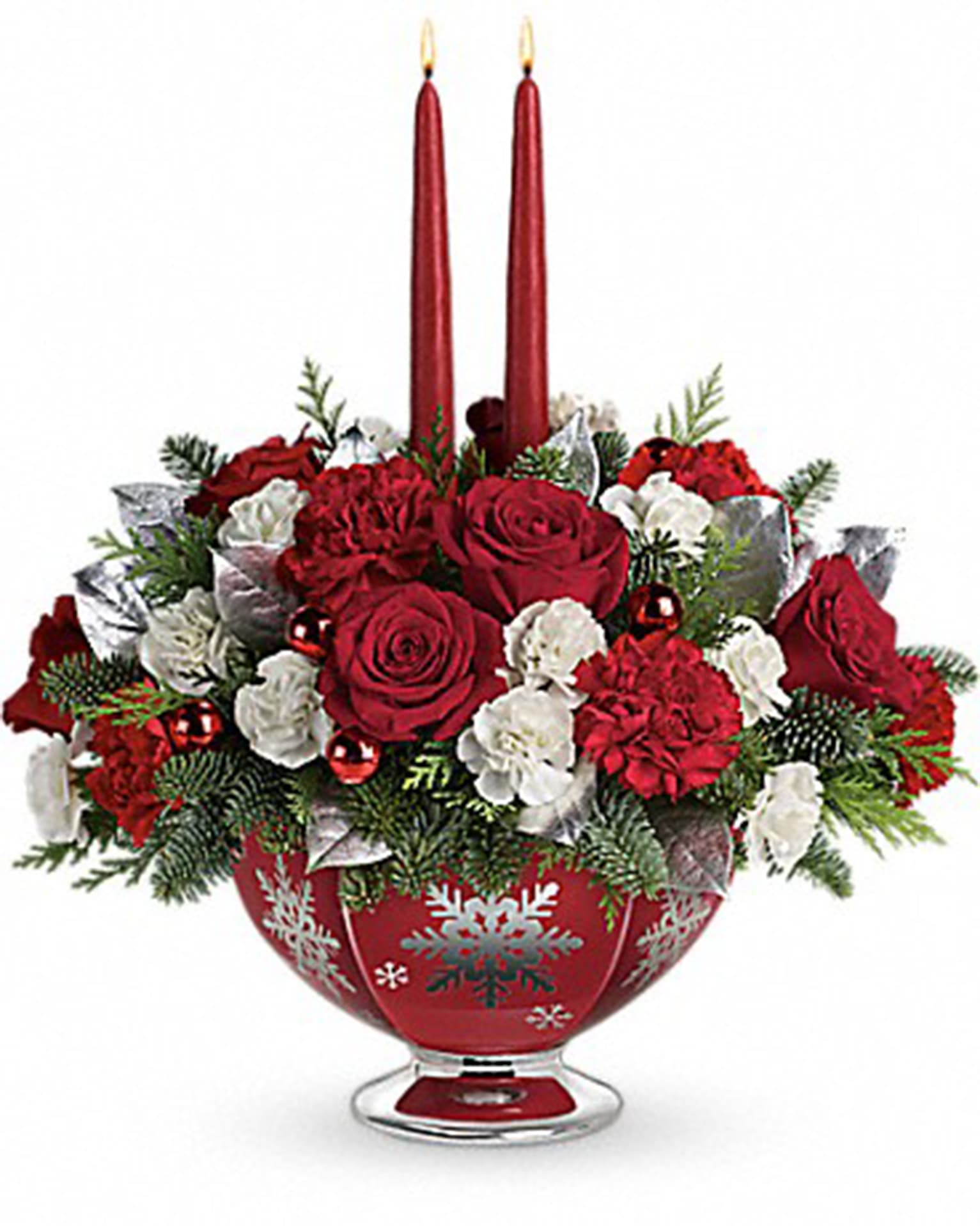 Silver and Joy Centerpiece - Make the season bright with shimmering snowflakes, glowing tapers and radiant holiday blooms. This elegant, hand-glazed ceramic bowl sparkles with silver snowflakes beneath beautiful red roses, carnations and winter greens. The food-safe design will long bring joy to their holiday table!  Lush red roses, red carnations and white miniature carnations are arranged with lemon leaf, flat cedar and noble fir. Delivered in a Silver And Joy bowl.