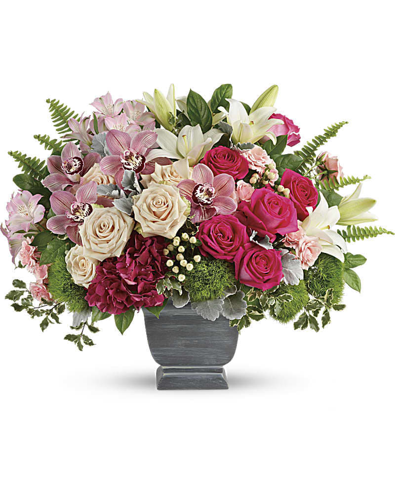 Teleflora's Grand Beauty Bouquet - A truly awe-inspiring arrangement this breathtaking bouquet blends roses hydrangea and orchids in a pretty palette of pinks. Accented with fresh greens in an elegant gray pot it's a grand gift they'll never forget! This grand arrangement features dark pink hydrangea pink cymbidium orchid blossoms crÃ¨me roses hot pink roses white asiatic lilies light pink alstroemeria green trick dianthus peach hypericum sword fern dusty miller pitta negra and lemon leaf. Delivered in a Modern Heritage pot.