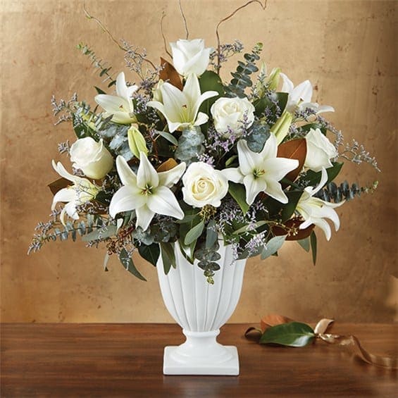 Graceful Style™ By Southern Living® For Sympathy - EXCLUSIVE They lived their life with grace and elegance. Our beautiful new arrangement celebrates their spirit with an abundance of striking white blooms, lush greenery and textured natural accents. Created exclusively through our partnership with Southern Living®, this luxurious gathering is arranged by our skilled florists into an exquisite pedestal vase to honor the memory of a special loved one while bringing peace and comfort to those mourning their loss. •One-sided arrangement with white Oriental lilies and roses; purple limonium; accented with seeded eucalyptus, spiral eucalyptus, magnolia tips and curly willow tips •Lilies may arrive in bud form and will open to full beauty in 2-3 days •Our florists select the freshest flowers available, so colors and varieties may vary due to local availability •Appropriate for the services or home •Fluted design pedestal vase in soft polished stone with white matte finish; measures 10.4&quot;H x 9.5&quot;L •Arrangement measures approximately 21&quot;H x 14&quot;L About Southern Living® Capturing the essence of Southern lifestyle, Southern Living® shares authentic experiences and their love of florals in an exclusive new partnership with 1-800-Flowers.com. We’ve captured that spirit by creating arrangements and one-of-a-kind gifts that deliver beauty and Southern charm