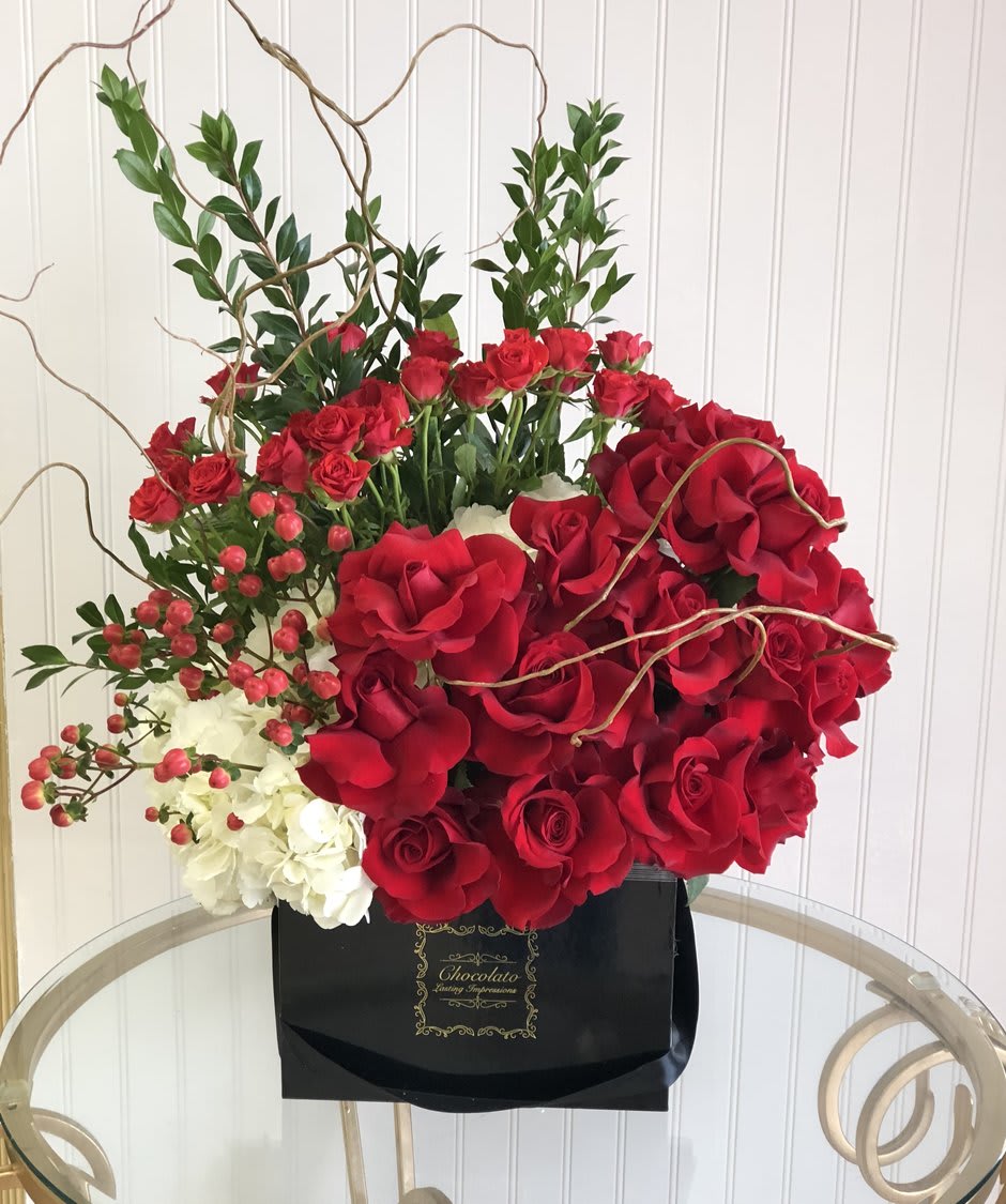 Christina - Roses, Spray Roses, Myrtle, Curly Willow, Hypericum Berries and More! - This Chocolato arrangement is made with red roses, spray roses, myrtle, curly willow, greenery, hypericum berries and lush white hydrangeas. The arrangement comes in a black square box.   Please see care instructions for further assistance on taking care of your Chocolato Boxed Flowers.  All prices are subject to change due to season and availability of fresh flowers. The arrangement seen is what will be made unless any substitution may need to be made based on season and availability of flowers.
