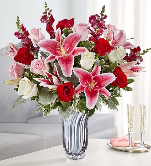 Radiant Devotion™ Bouquet -  Let your feelings of love and devotion out with our lush and lavish bouquet. Created by Carrie South, as part of our local artisan design workshop, it’s filled with romantic red, pink and white blooms, hand-gathered in our exclusive Silver Radiance Vase. Flaunting soft, silvery cascades through glistening mercury glass, it’s a gift that won’t leave them wondering what’s in your heart. All-around arrangement with pink, white and red roses, pink Stargazer lilies and burgundy snapdragons; accented with assorted greenery Artistically designed in our Silver Radiance Vase, an elegantly proportioned vessel with soft, fluted cascades throughout; measures 8&quot;H x 4&quot;D Our florists select the freshest flowers available, so colors and varieties may vary due to local availability