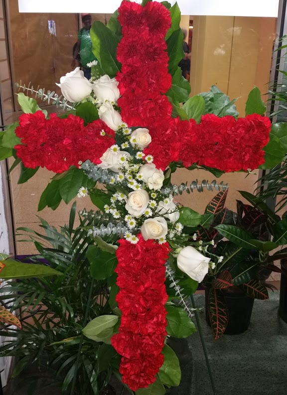 Red &amp; White Standing Cross - Our splendid cross is made out of carnations, roses, and eucalyptus. It is a wonderful piece that will be at your loved one's service to bring peace and serenity. The cross is placed on a 54&quot; easel. 