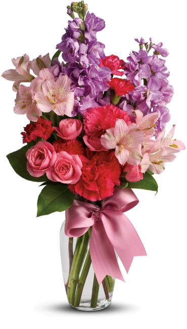 Jumping for Joy -   Send her on a dreamy stroll through a garden with this perfect-for-any-occasion bouquet. Soft lavender and pink flowers delight with a sweet smell; a pink ribbon adds to the feminine look of this traditional arrangement.  Lush lavender stock, pale pink alstroemeria, hot pink spray roses and mini carnations are delivered in a traditional glass vase adorned with a pink ribbon. 