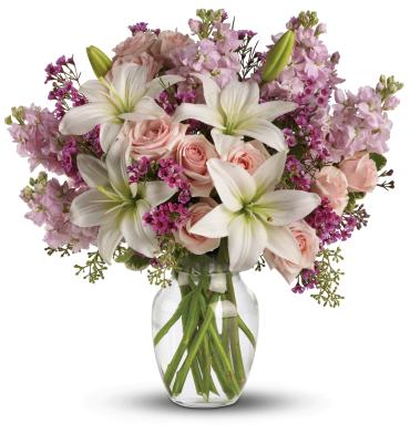 Blossoming Romance -   Think of someone you love. Then think how thrilled they'll be when this gorgeous bouquet arrives at the door. Light pink spray roses, fragrant white lilies and other favorites in a sparkling glass vase - they'll be floating on air all week.  This lovely bouquet includes light pink spray roses, white asiatic lilies, lavender stock and lavender waxflower accented with assorted greenery. 