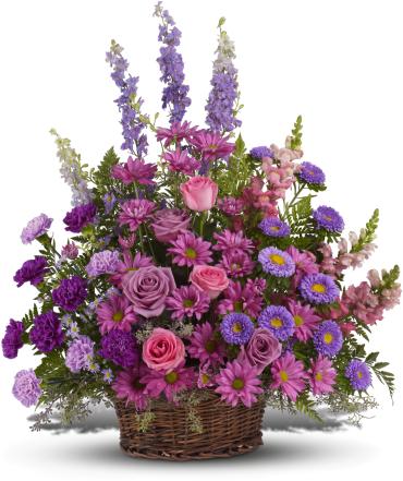 Gracious Lavender Basket -   Soothing jewel tones of lavender, purple and pink come together to celebrate a life and comfort friends and loved ones - an abundant basket of fragrant country blooms that pays tribute to someone truly special.  Purple, pink and lavender petals abound in a lovely mix of flowers such as roses, carnations, snapdragons, larkspur, matsumoto and monte cassino asters, nestled among leatherleaf fern and eucalyptus in a round wicker basket. 