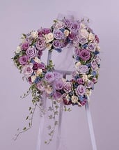 TRIBUTE OF LIFE - A BEAUTIFUL HEART ,DISPLAYED WTH LOVELY LAVENDER AND WHITE TONES. ROSES AND IVY, ACCENTED WITH A BOW.  DISPLAYED ON A 5 FOOT EASEL.. A SURE WAY TO EXPRESS YOUR DEEPEST SYMPATHIES.
