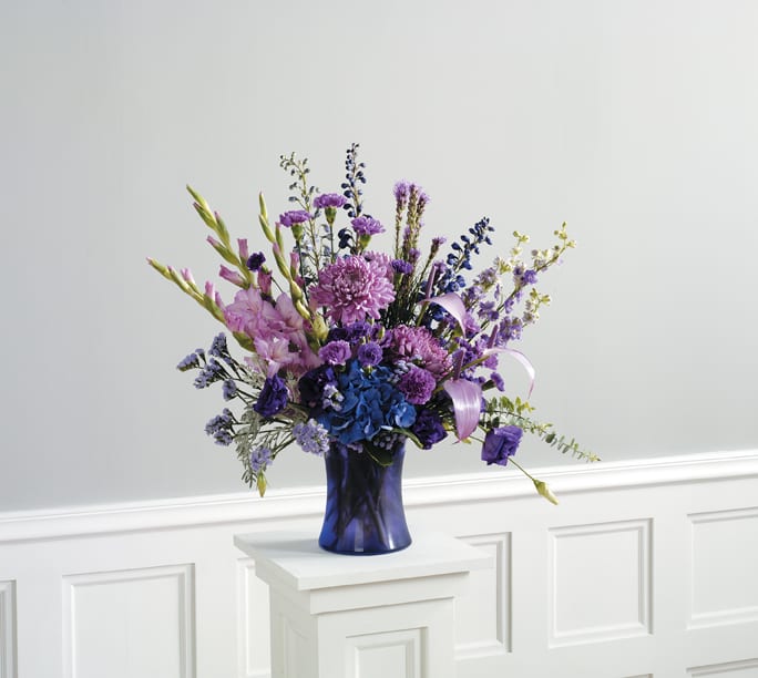 LAVENDER BEAUTY LAVENDER BEAUTY - FRESH BEAUTIFUL ROSES, SNAPS, IRIS AND MORE. ALL IN FESTIVE PURPLE TONES. CONTAINERS MAY VARY