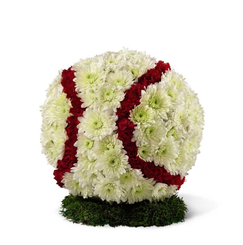 All-American Baseball Tribute - The All-American Baseball Tribute is a memorable and unique way to celebrate this beloved pastime so cherished by your loved one. White chrysanthemums and red mini carnations form the shape and likeness of a baseball standing on a piece of lush green moss.